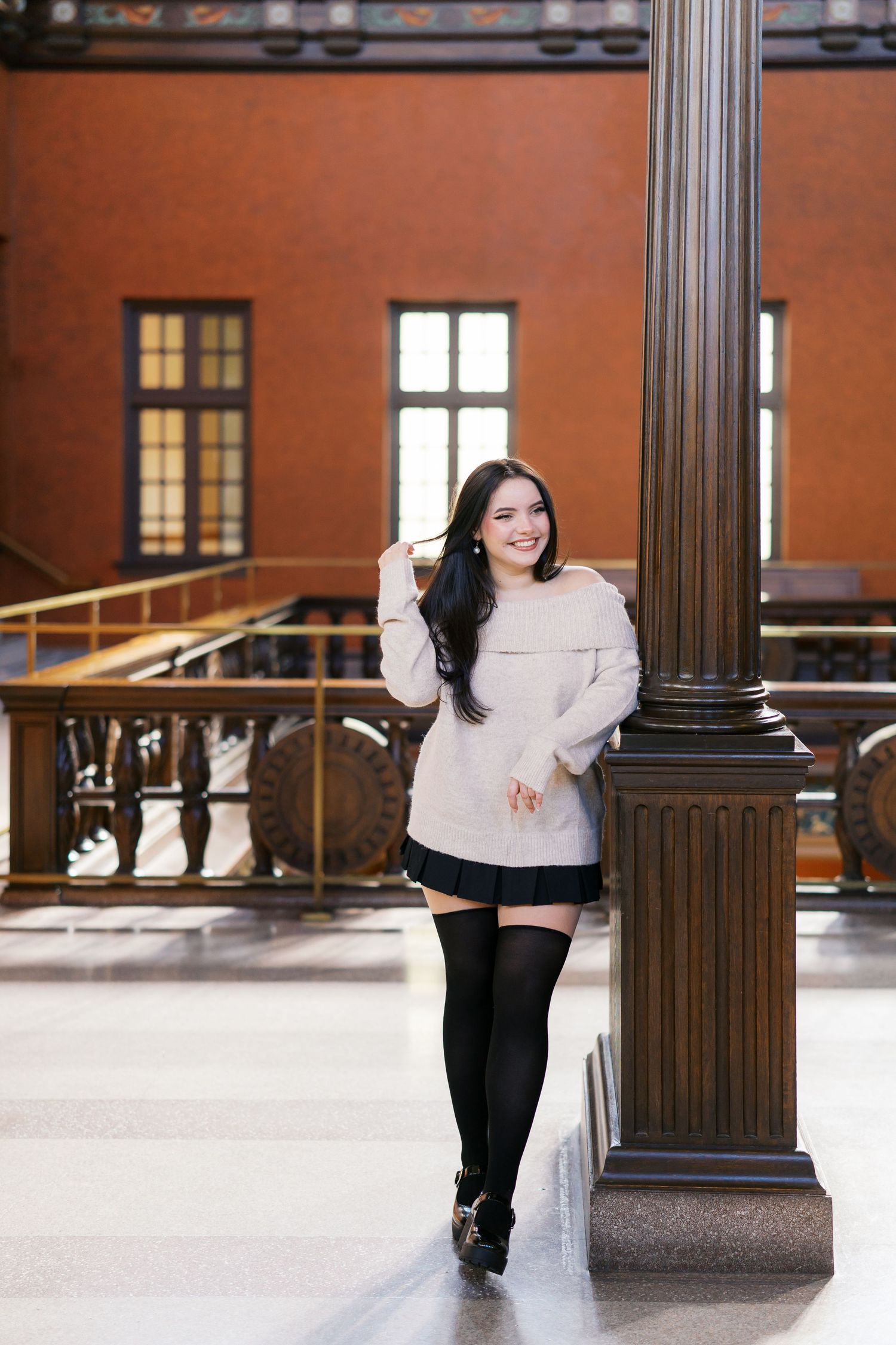 A series of five photos showing someone in a white top and black pants posing gracefully against brick columns and railings.