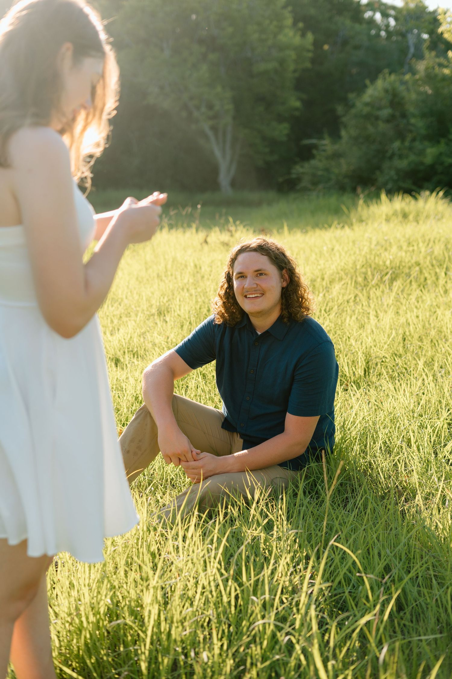 Candid moments in a sunlit grassy field during golden hour.