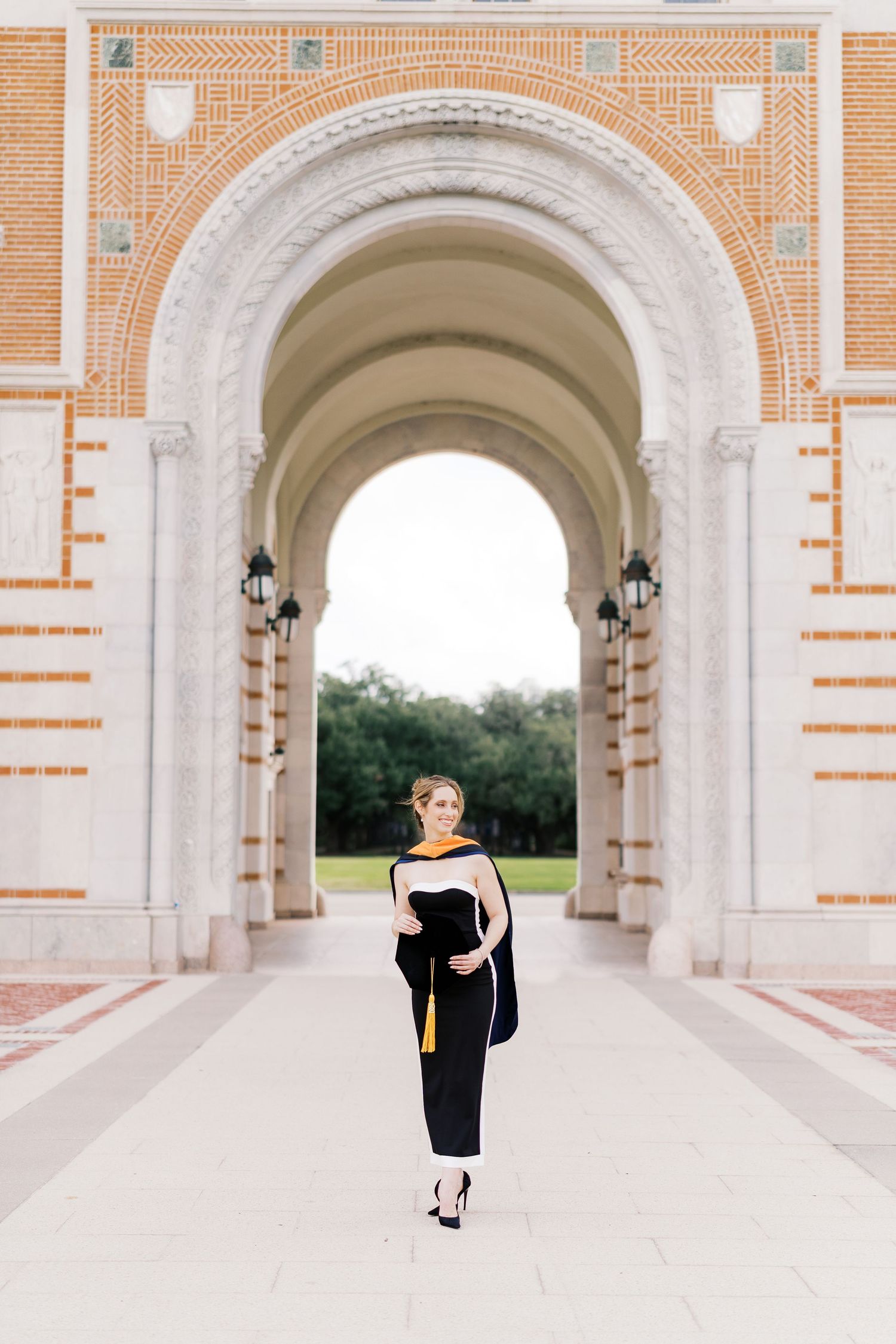 Elegant architectural photos showing a person walking through a grand colonnade with brick detailing.