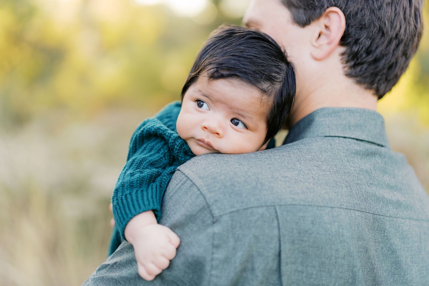 Close-up shots of a person in a teal sweater holding a small child.