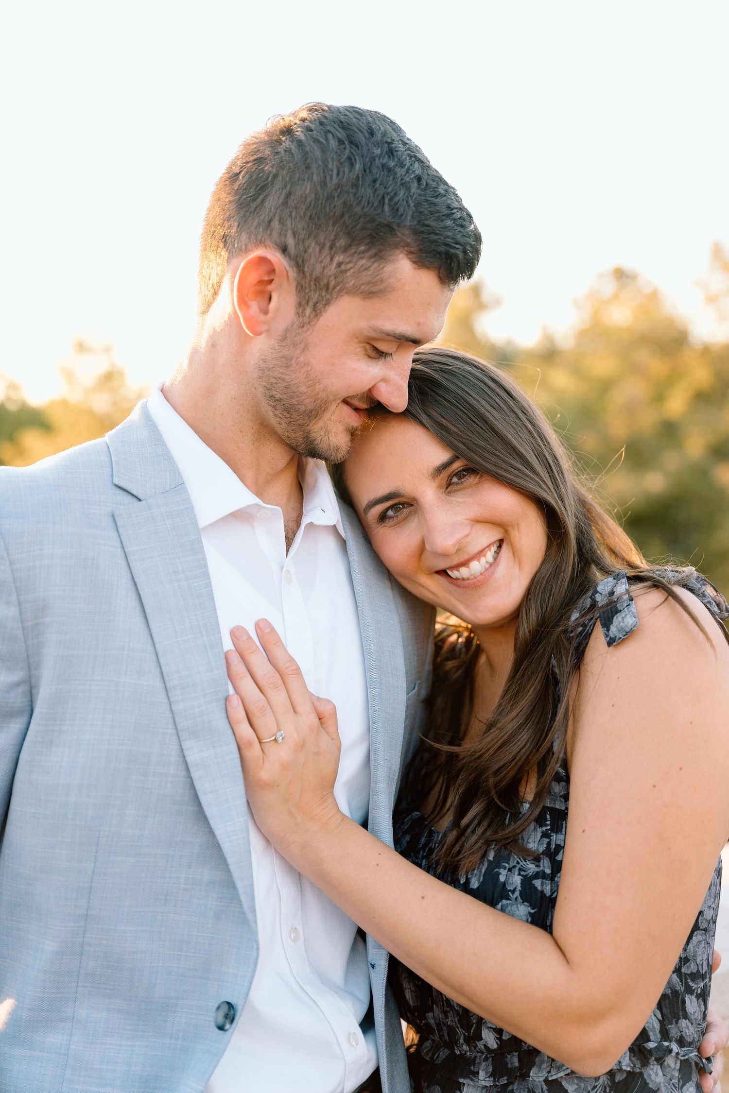 Romantic couple sharing intimate moments during a sunset photoshoot.