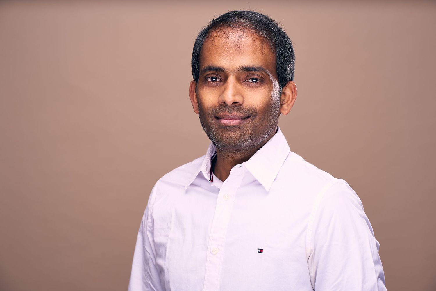 Professional headshot photos of someone wearing a white button-down shirt against a neutral background.