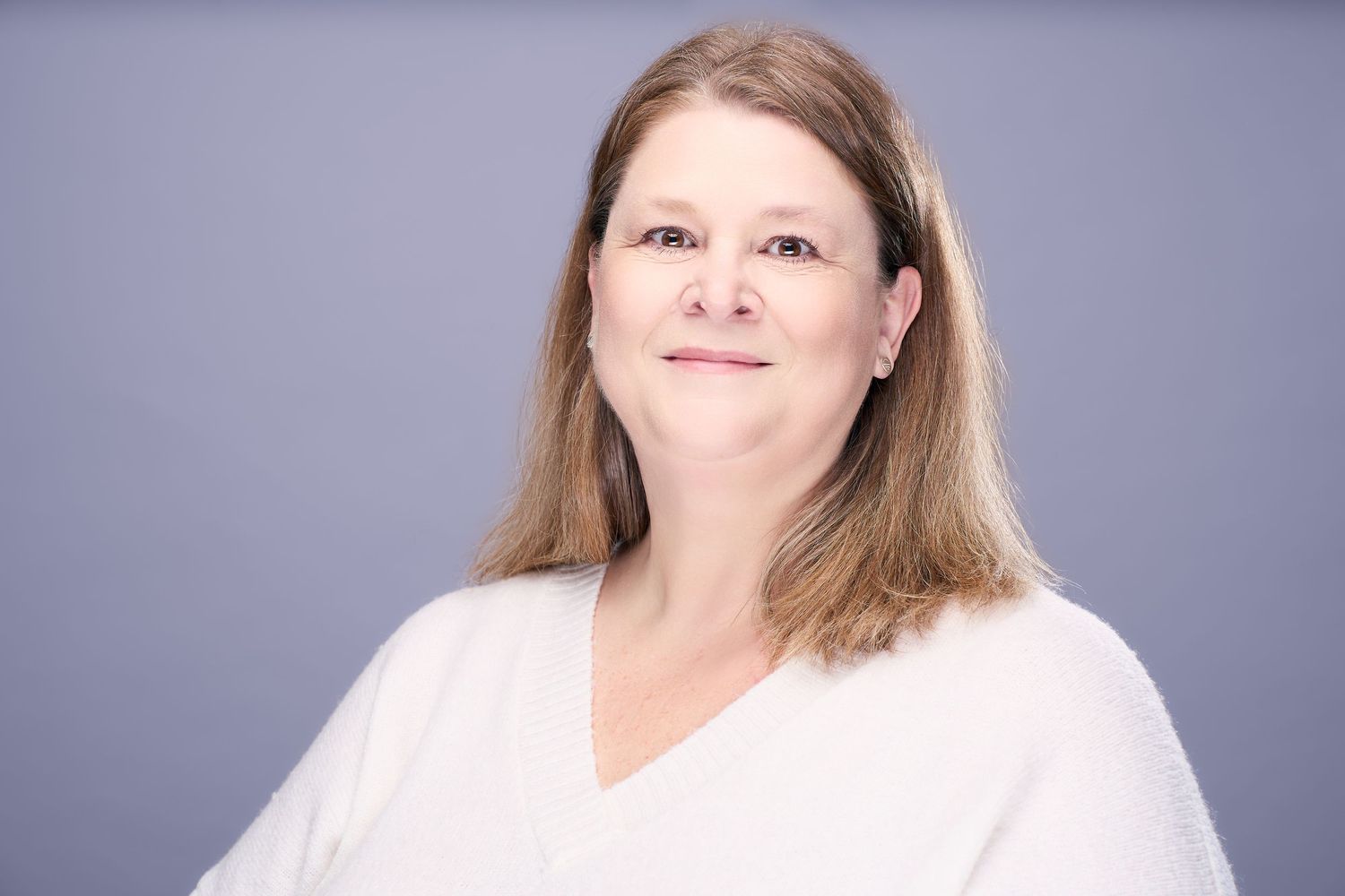 A series of professional headshots against a gray background showing different expressions and poses.