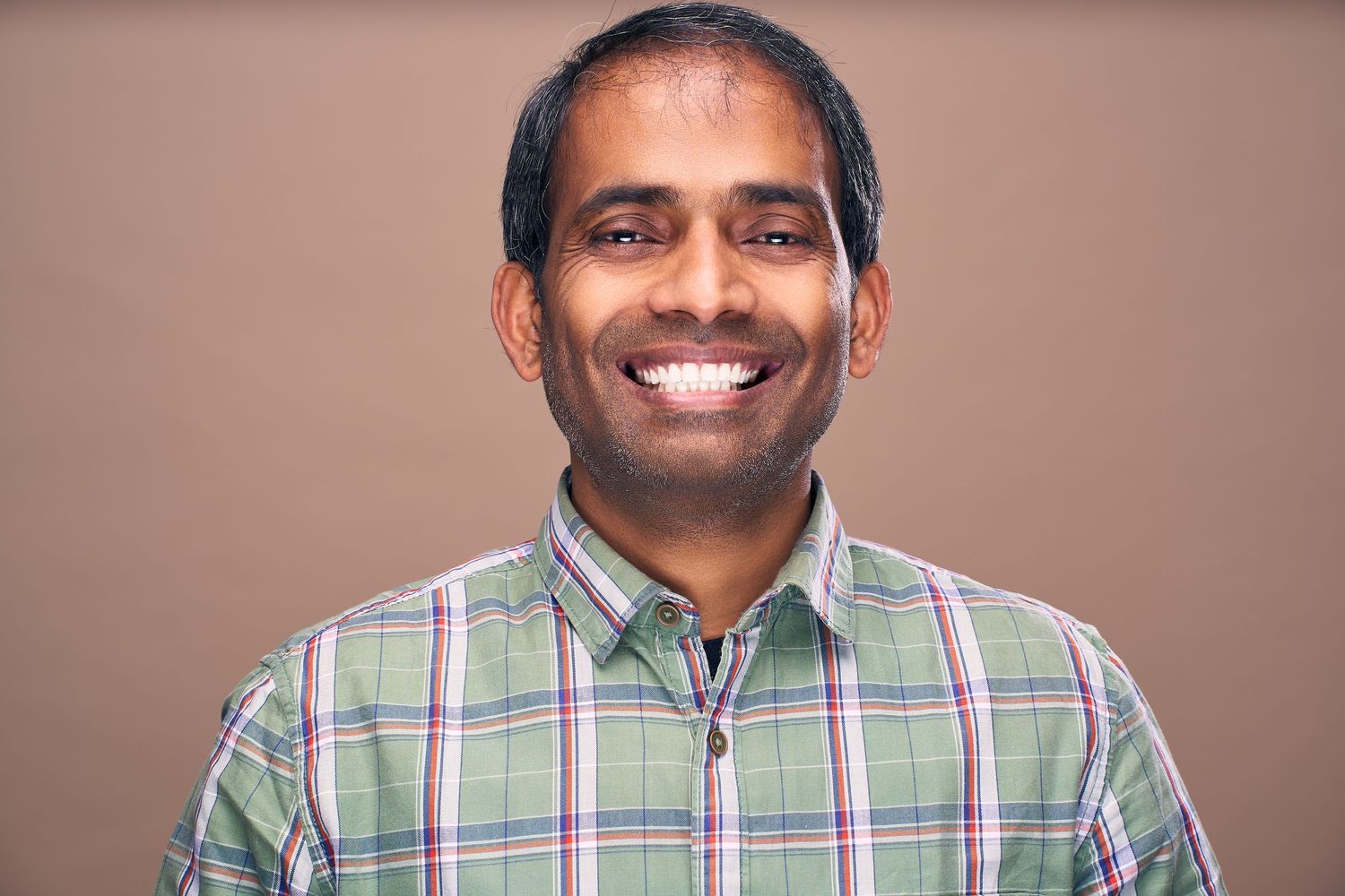 A series of six professional headshot photos showing someone in a plaid button-up shirt against a neutral background.