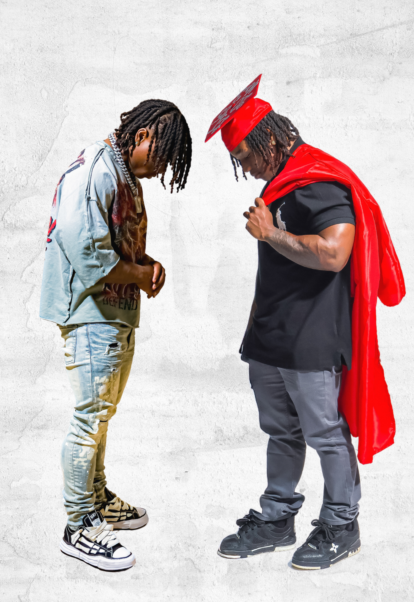 Two men face each other, one in red graduation cap and cape in creative portrait.