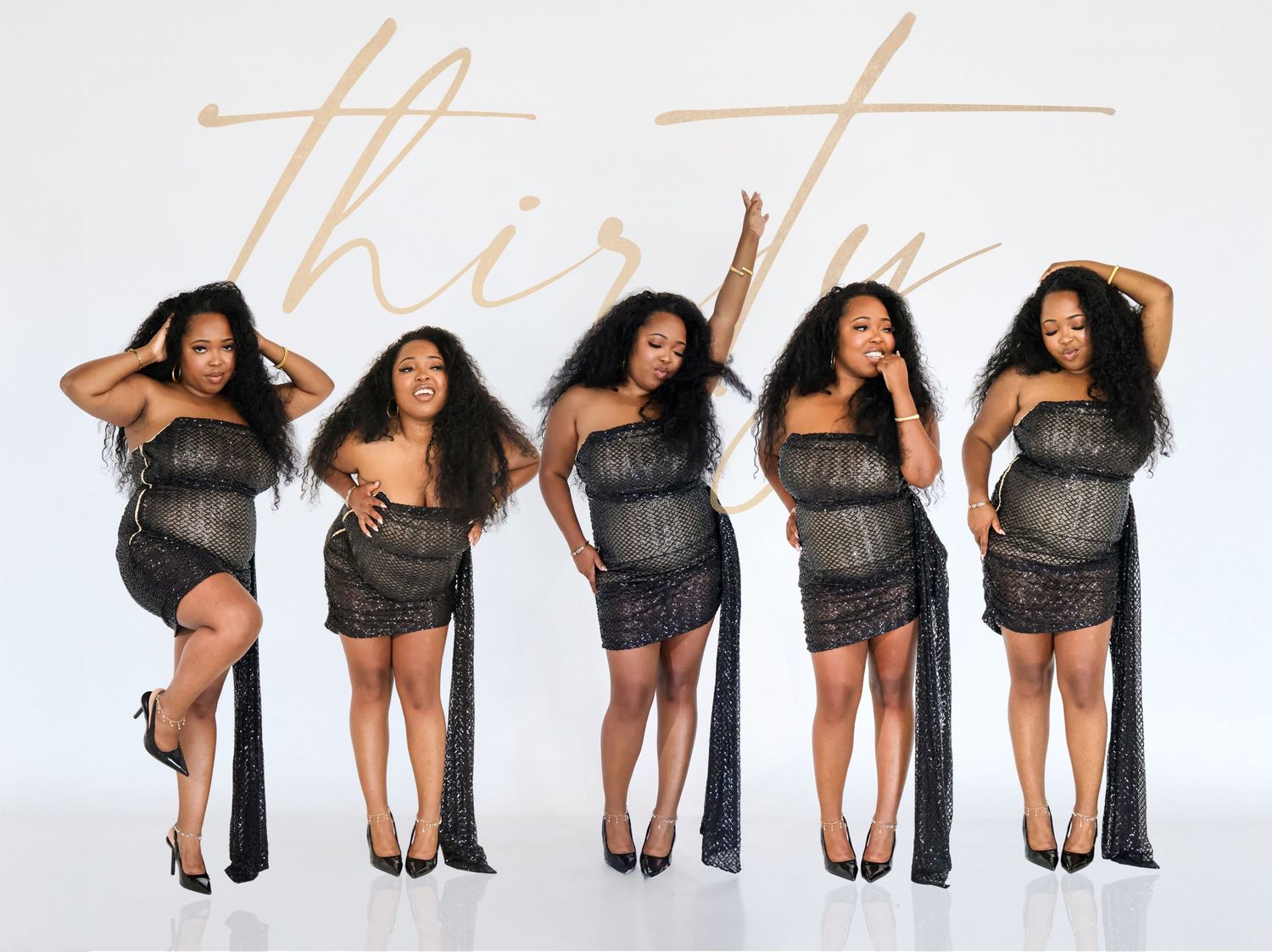 Five women in black sparkly outfits pose confidently in front of a white backdrop with cursive thirty text.