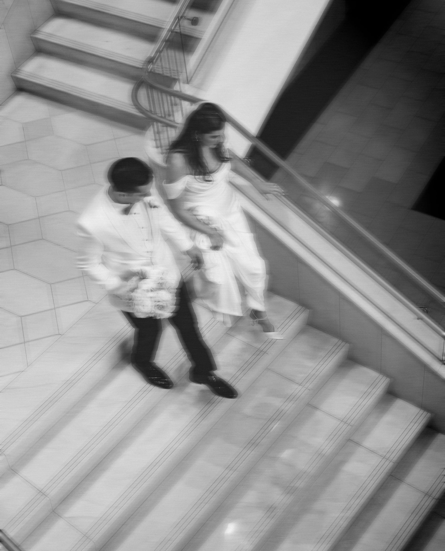 Black and white security camera footage showing movement in a hallway.