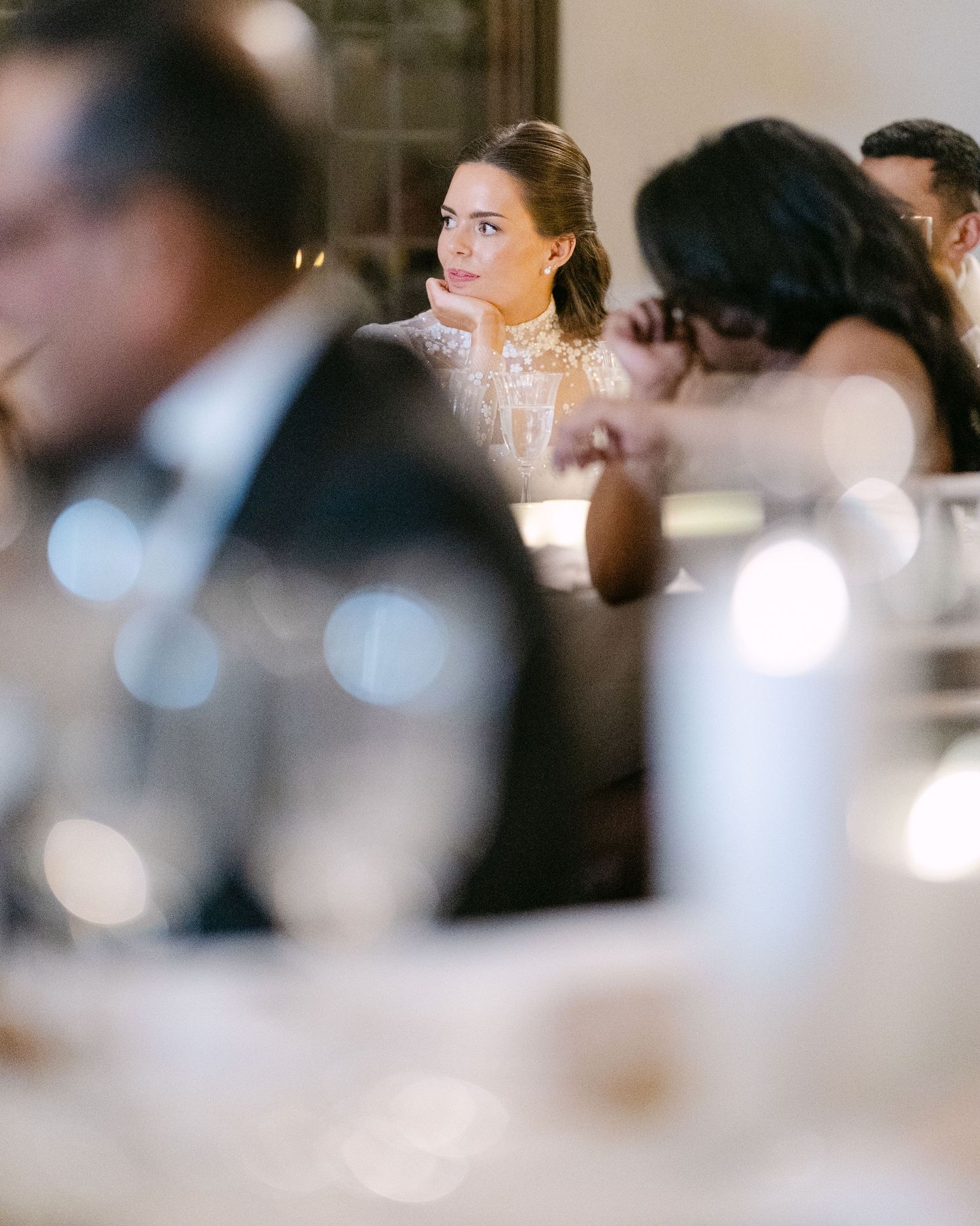 Soft focus wedding reception scene with elegant table settings and ambient lighting.