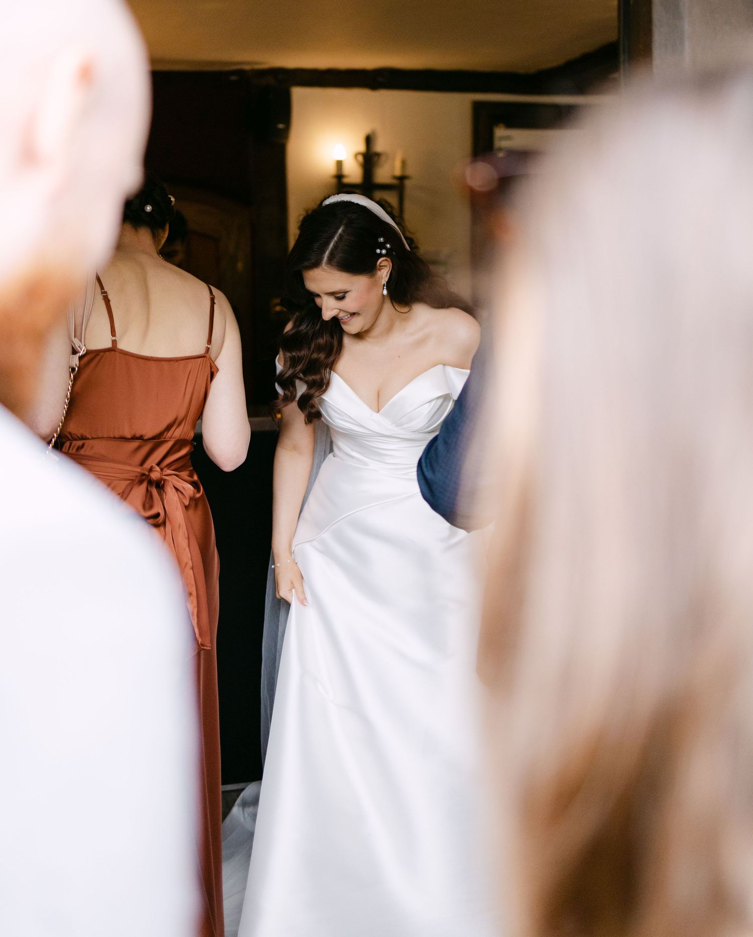 Wedding party members prepare in a dimly lit interior space.