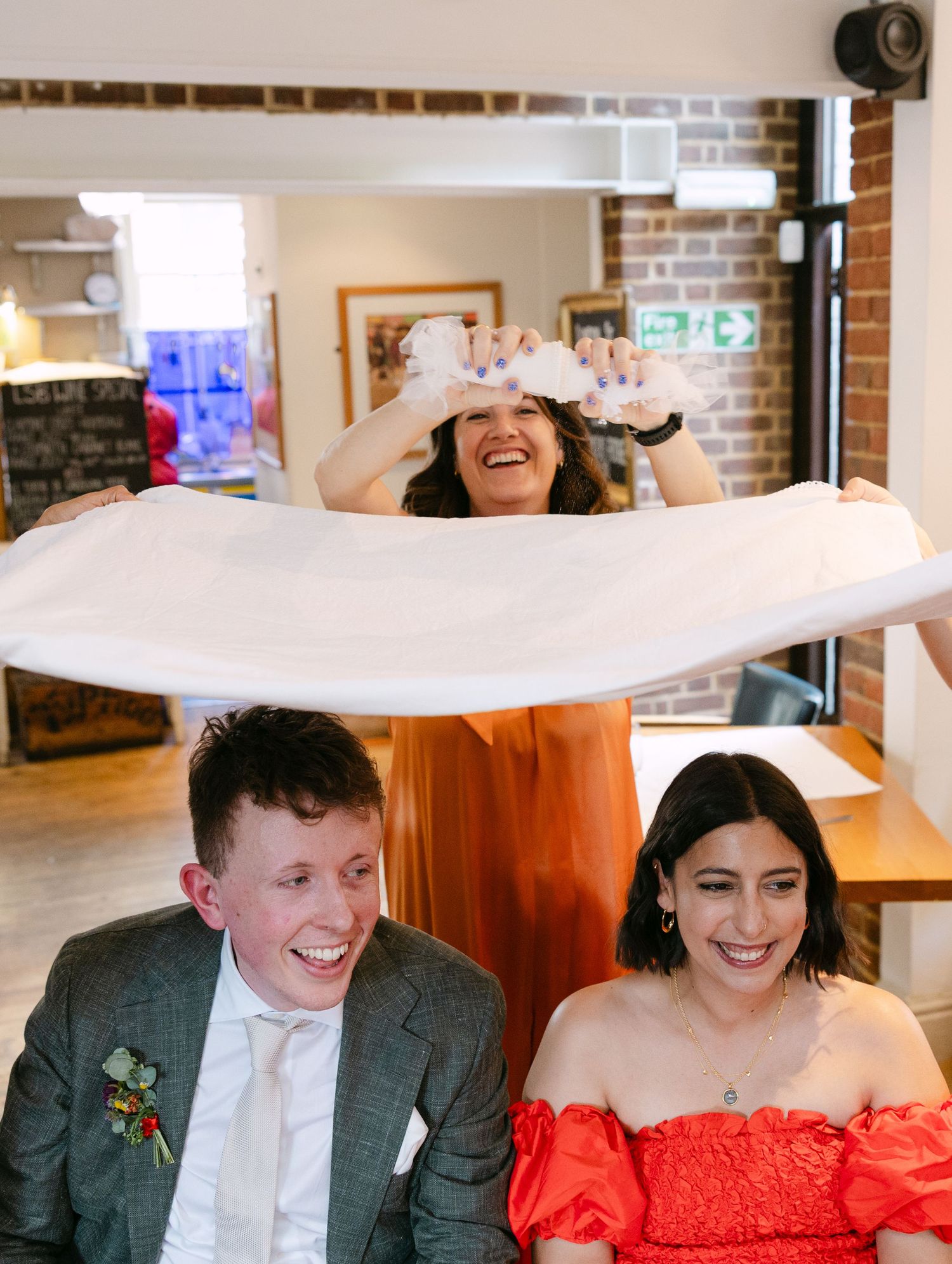 A joyful celebration at a restaurant with guests seated at tables.