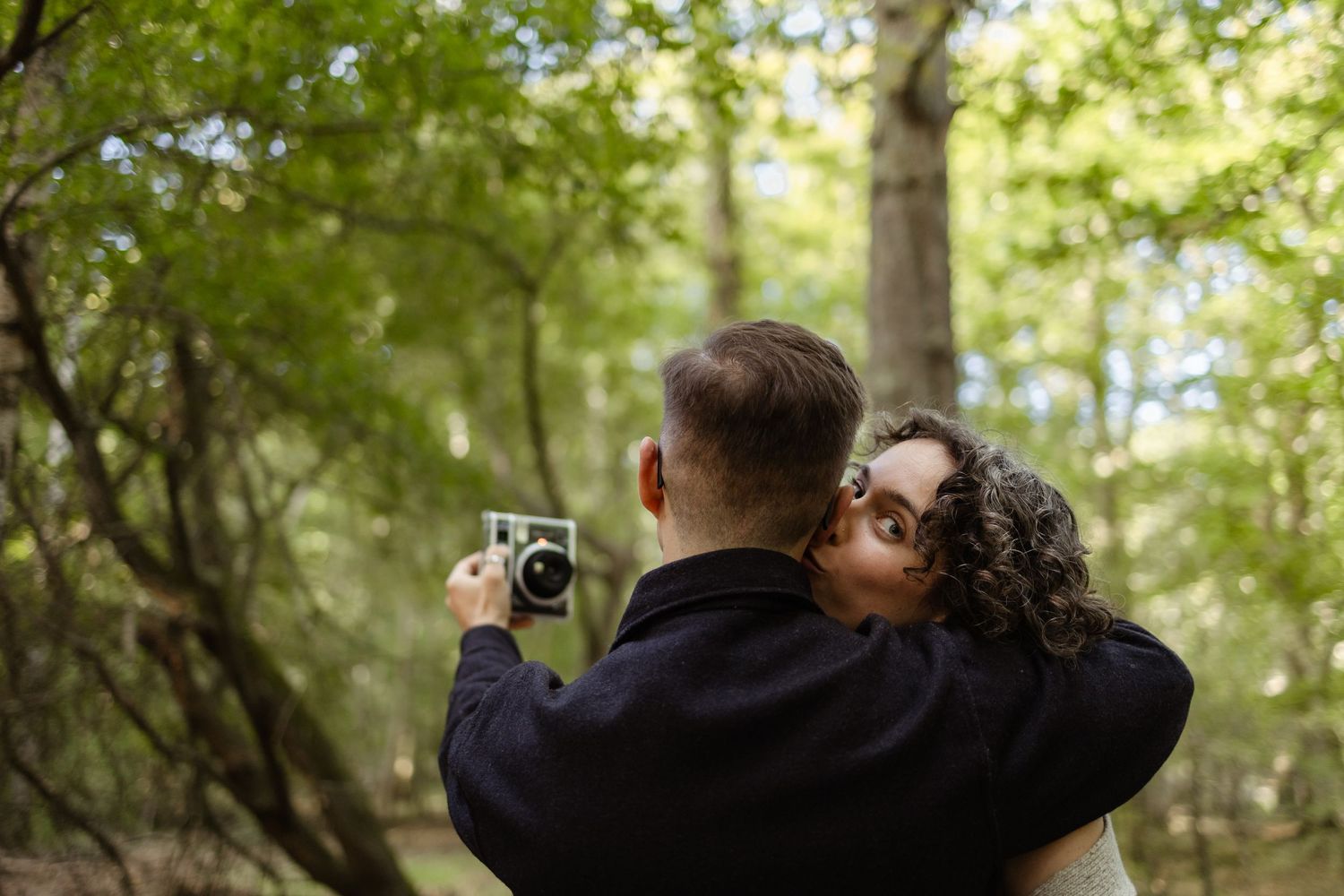 A romantic photoshoot sequence captured in a bright, sunlit forest.