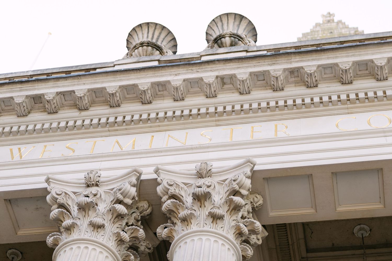 Ornate white classical architecture with decorative shell-shaped pediments and detailed moldings along the roofline.