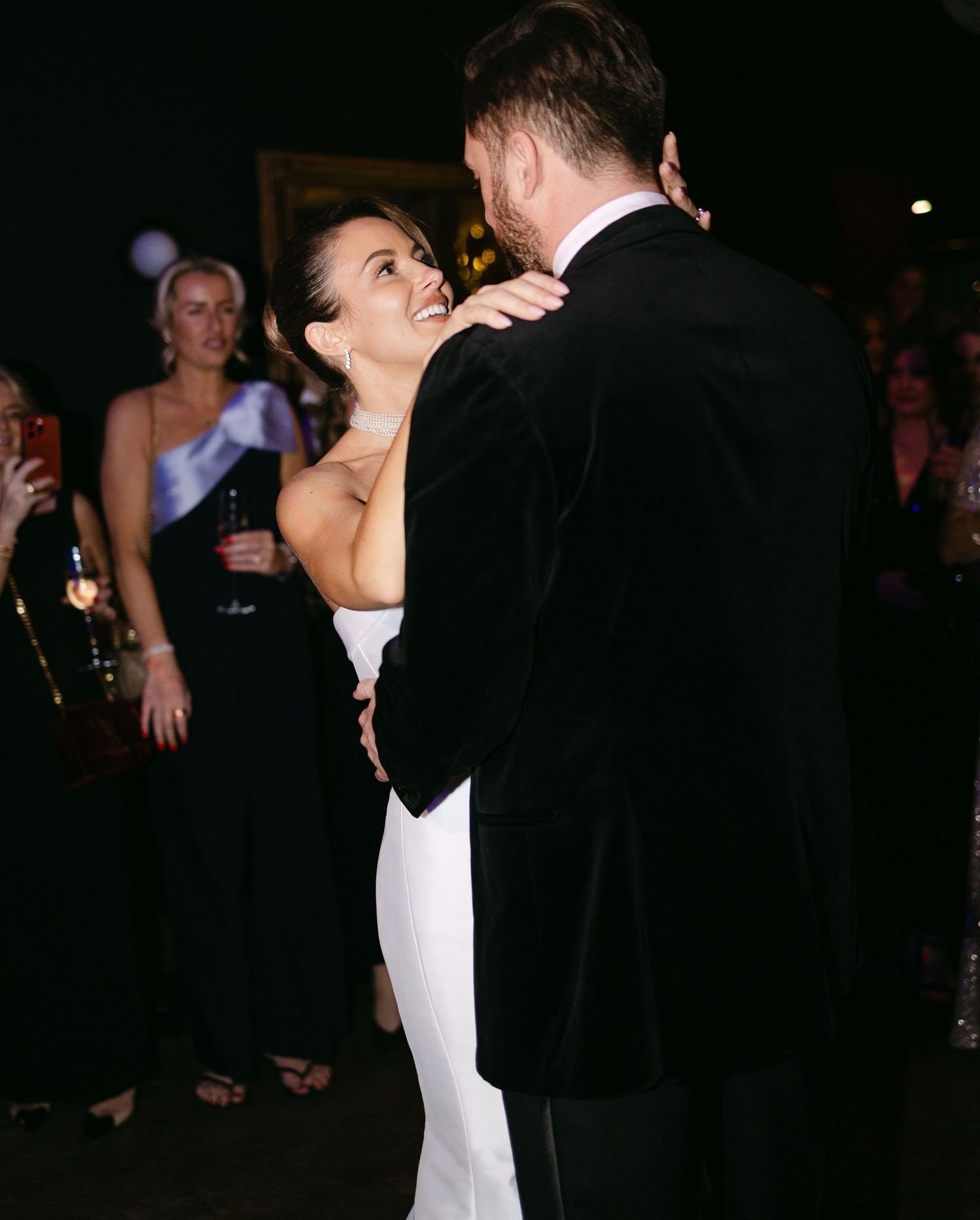 Couple embraces during romantic dance at their wedding reception.