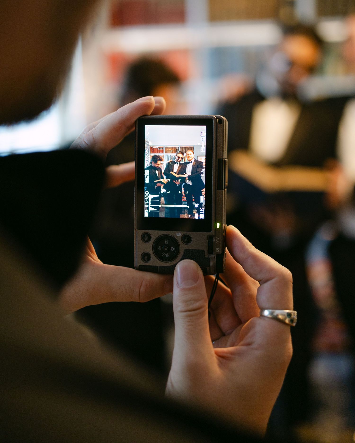 Someone taking photos with a digital camera at a wedding event.