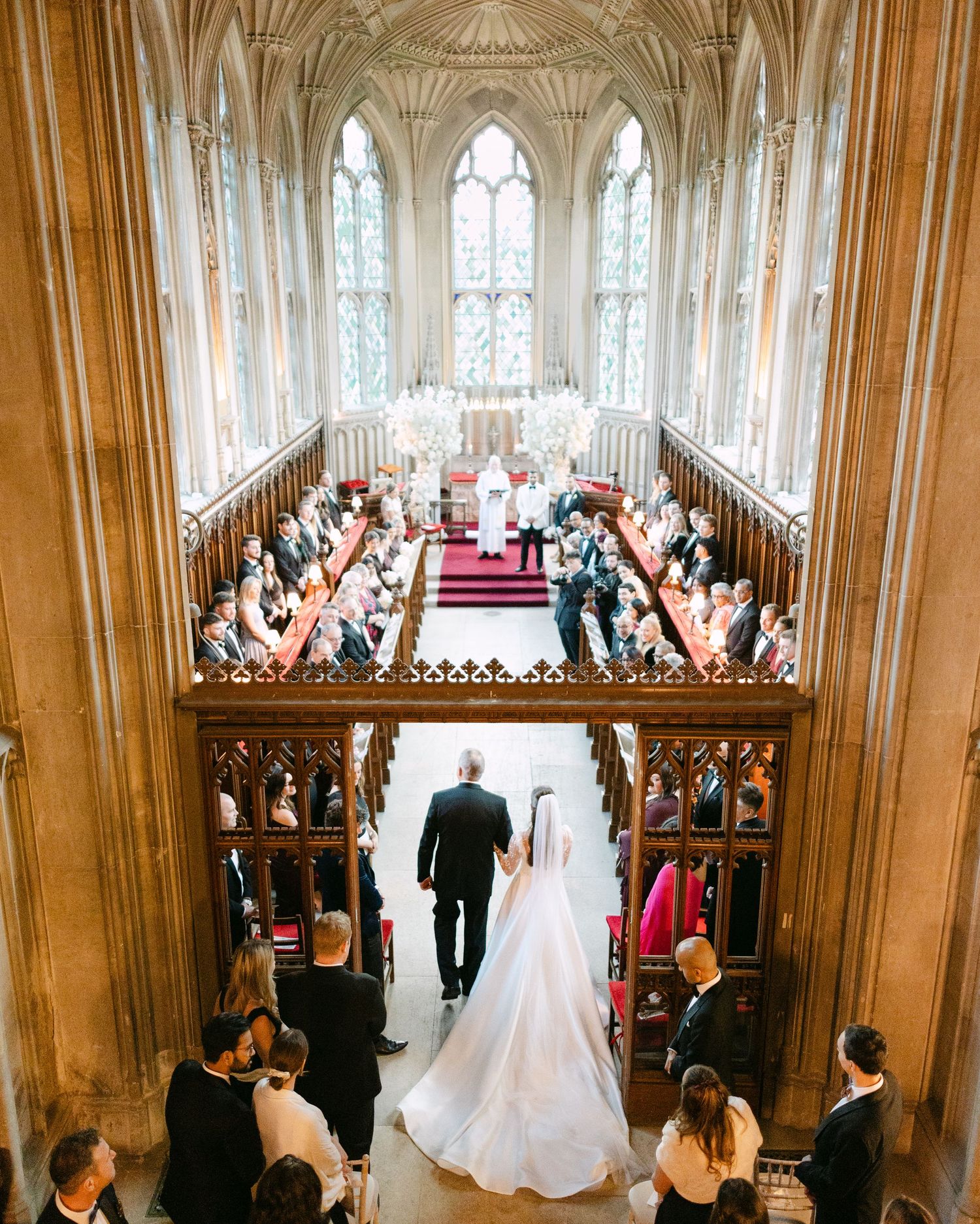 Elegant wedding ceremony in a grand cathedral with vaulted ceilings and ornate Gothic architecture.