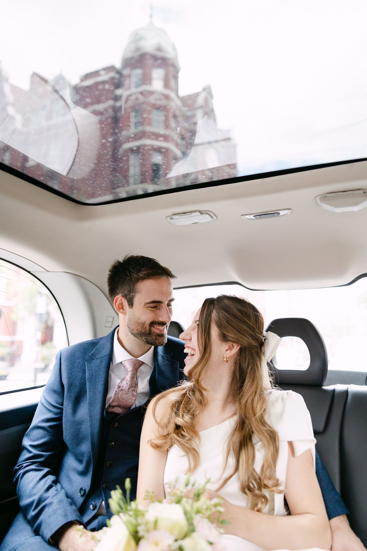 A romantic moment captured between a couple in the back seat of a London Taxi on their wedding day.