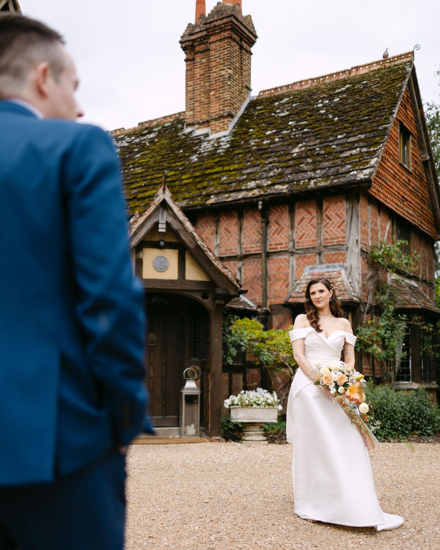 Wedding photos in front of historic brick Tudor-style building, Langshott Manor.