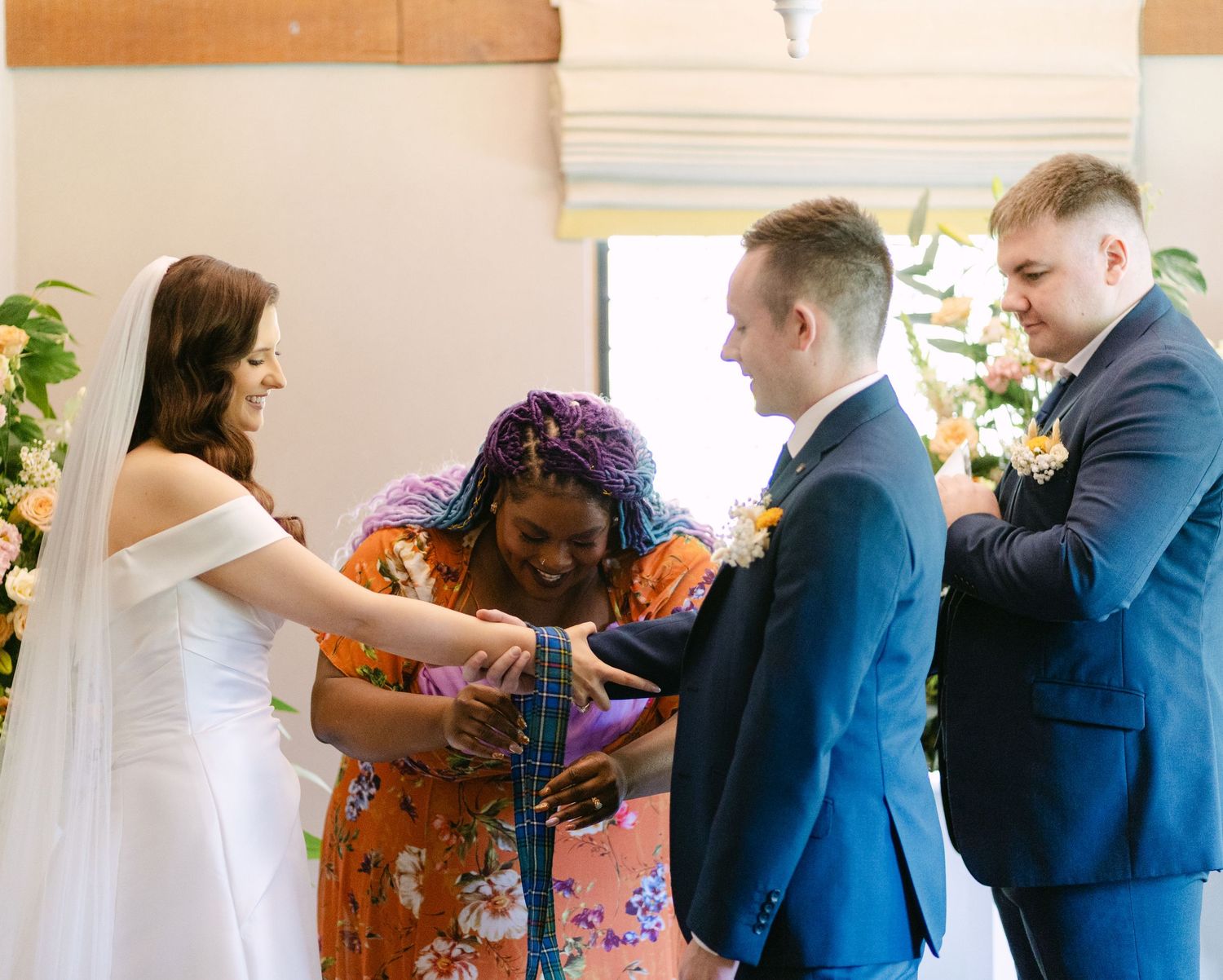 Wedding ceremony candid moments with attendees in formal attire and floral decorations.