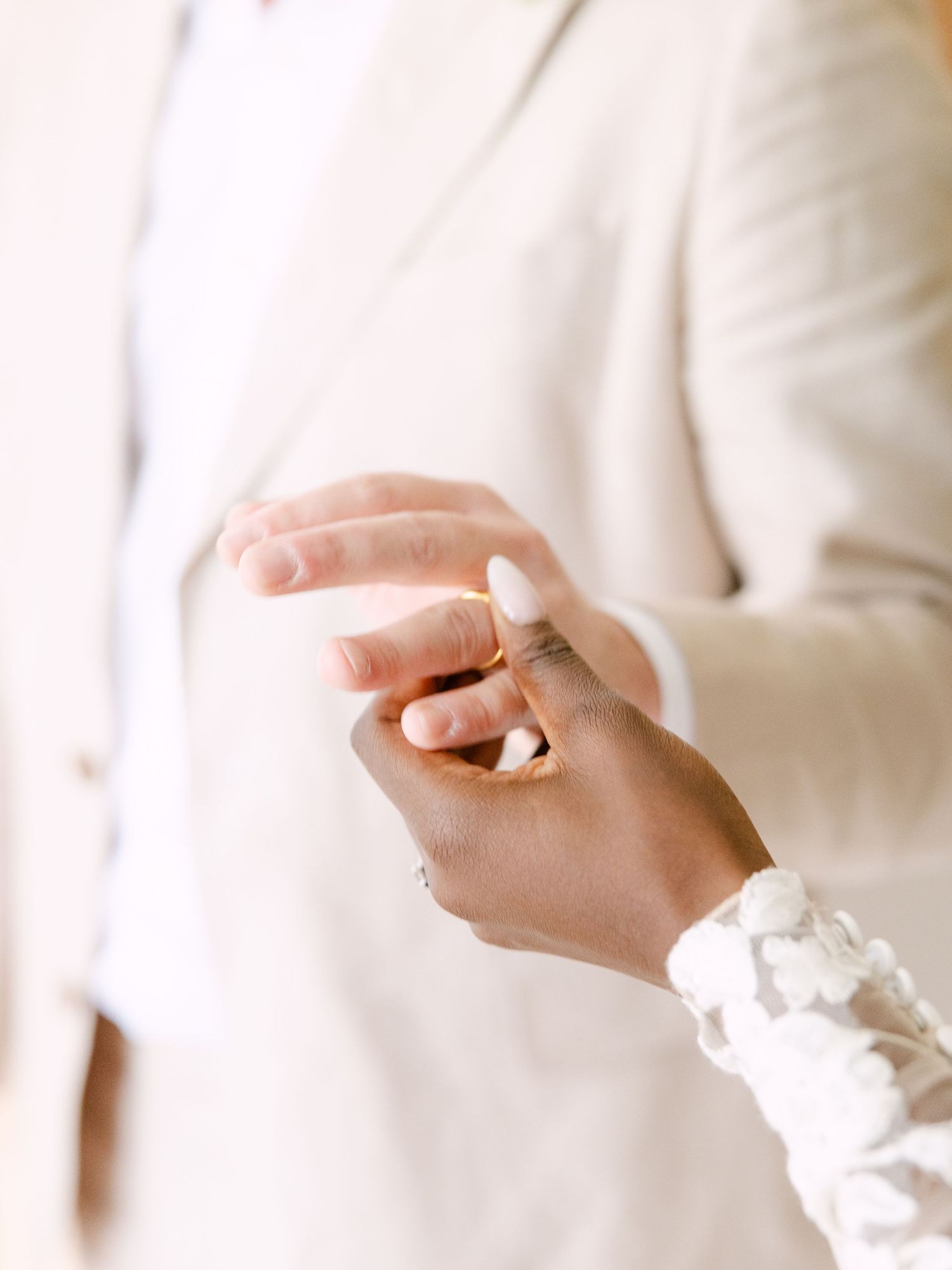 Close-up of hands wearing delicate white lace sleeves.