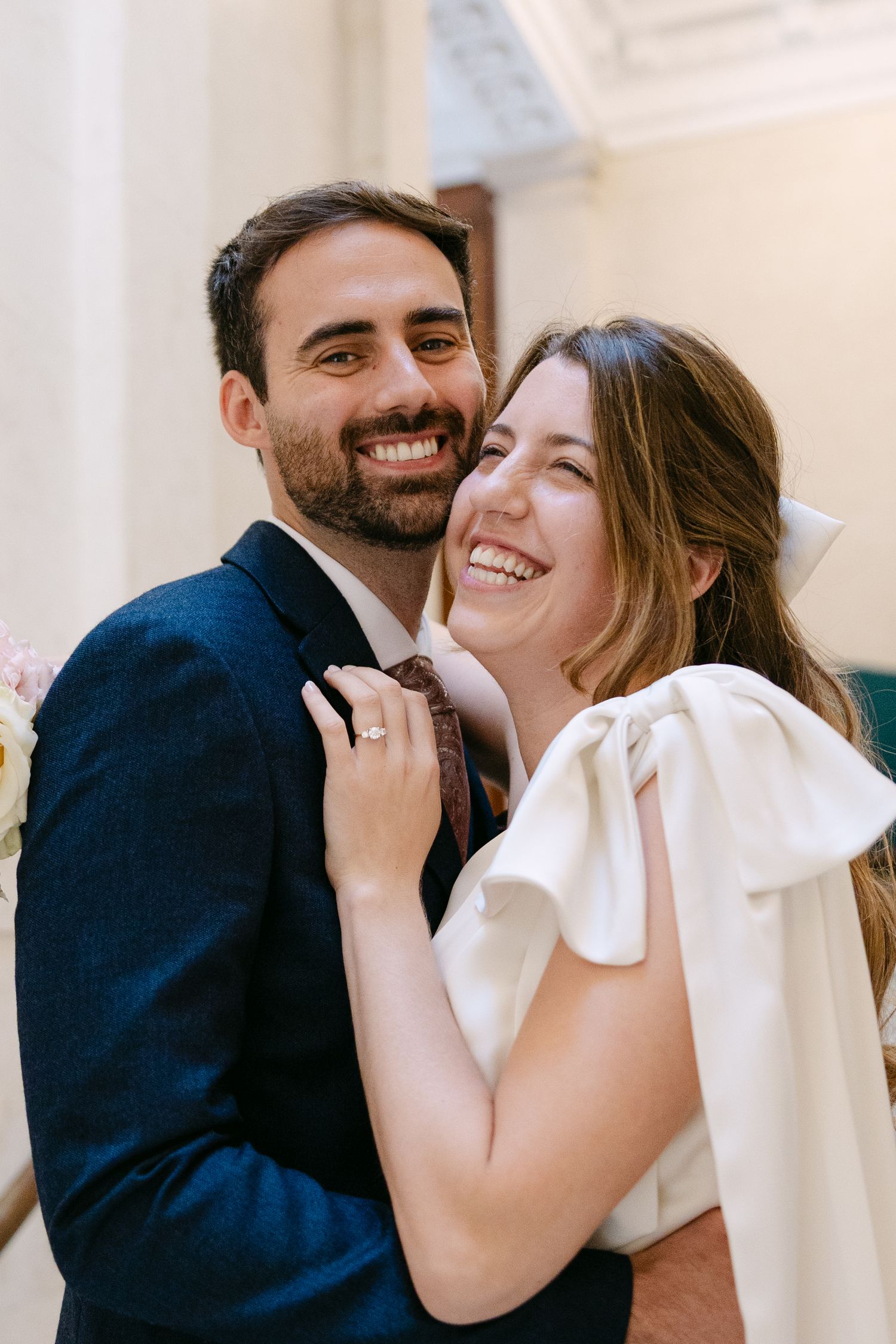 A joyful couple shares intimate laughter in a bright indoor setting.