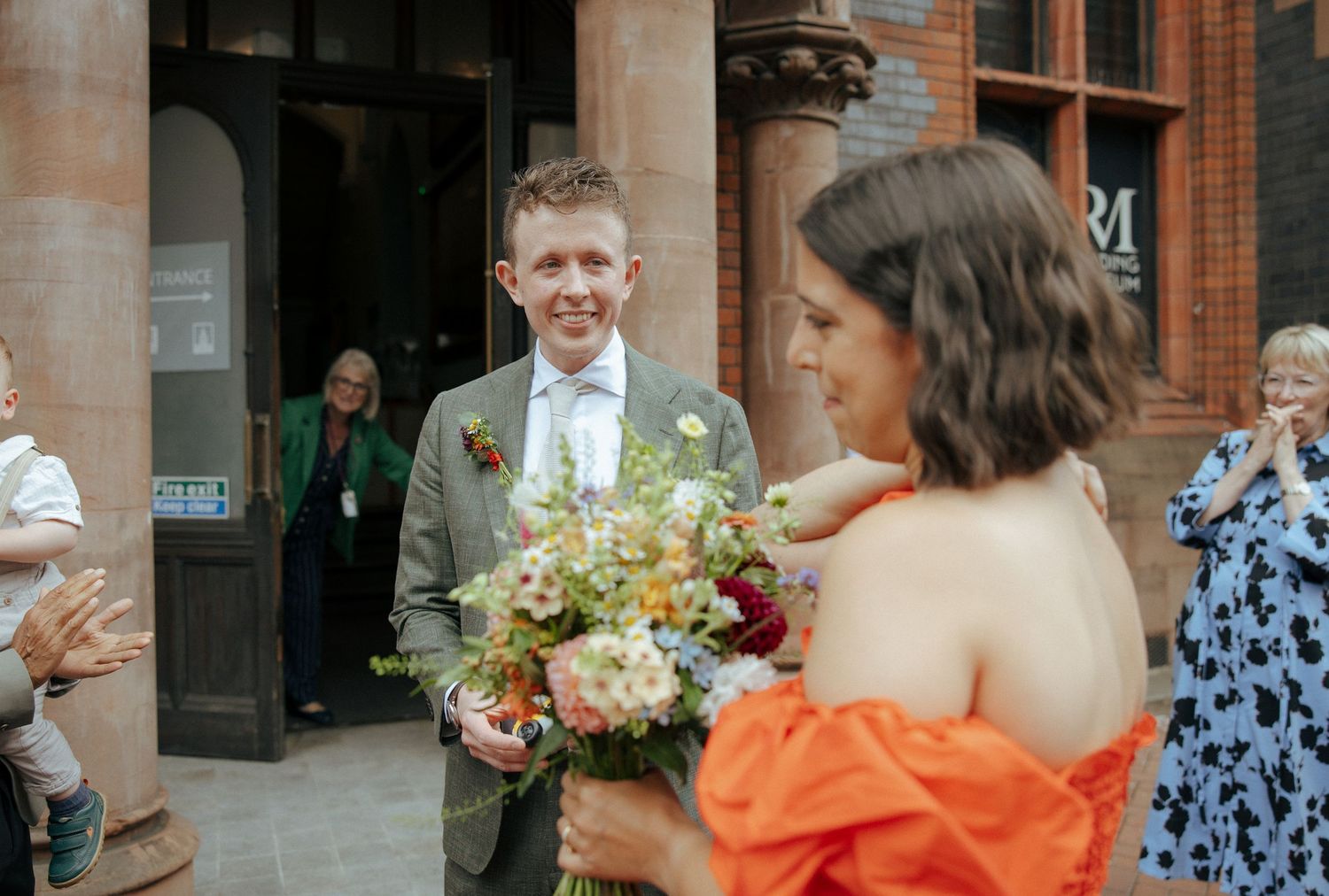 Bride and groom walking hand in hand outside Reading Town Hall after their micro wedding ceremony