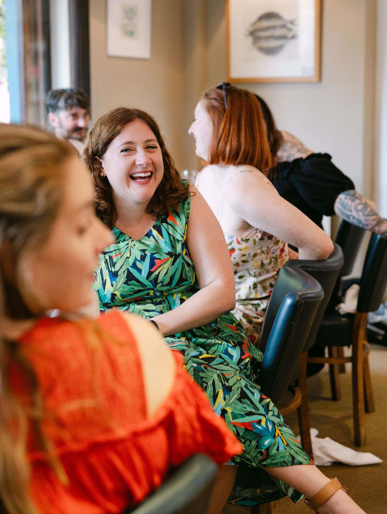 People sharing laughter and conversation during a festive indoor celebration.