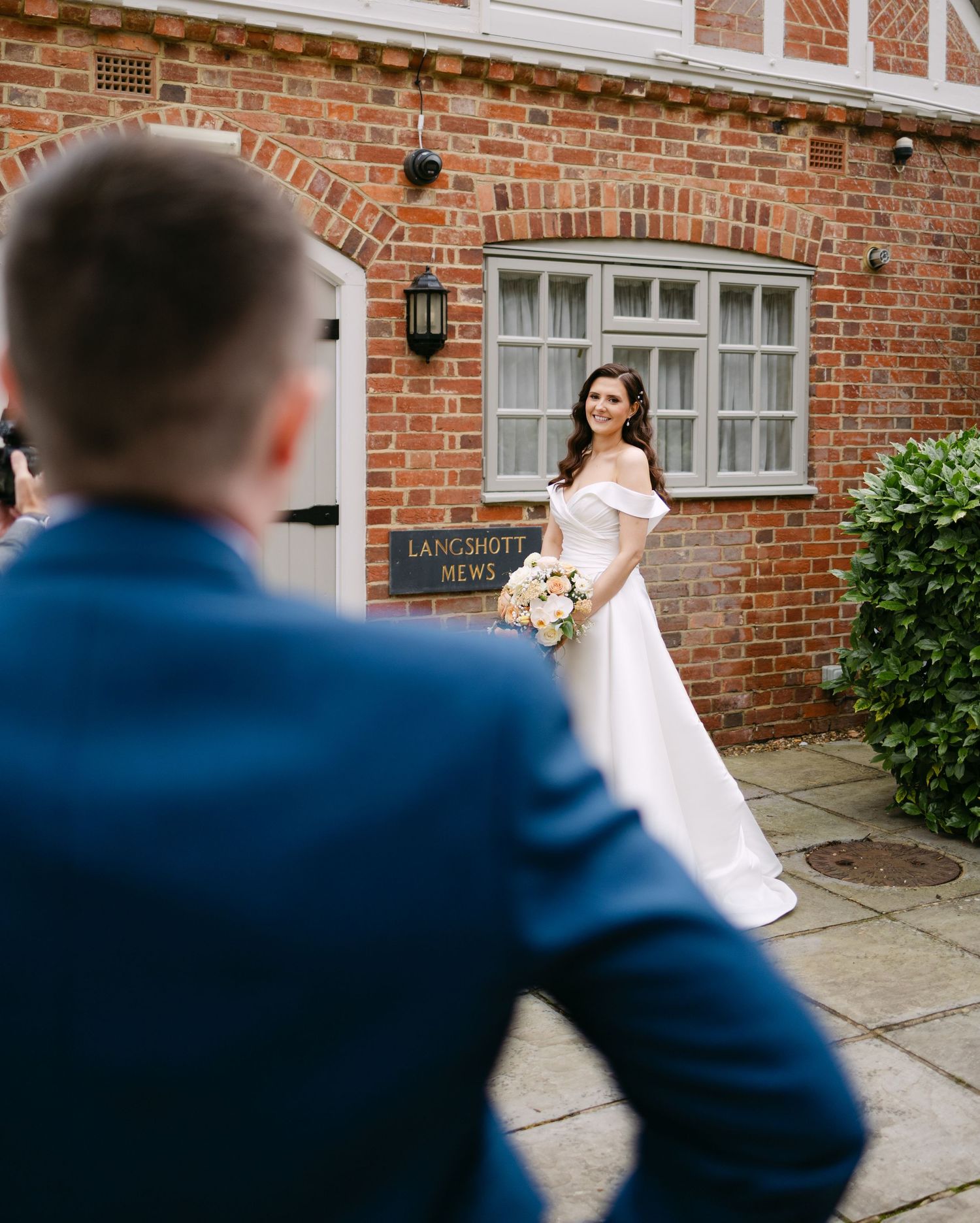 Wedding photography session outside brick building with white trim at Langshott Manor.