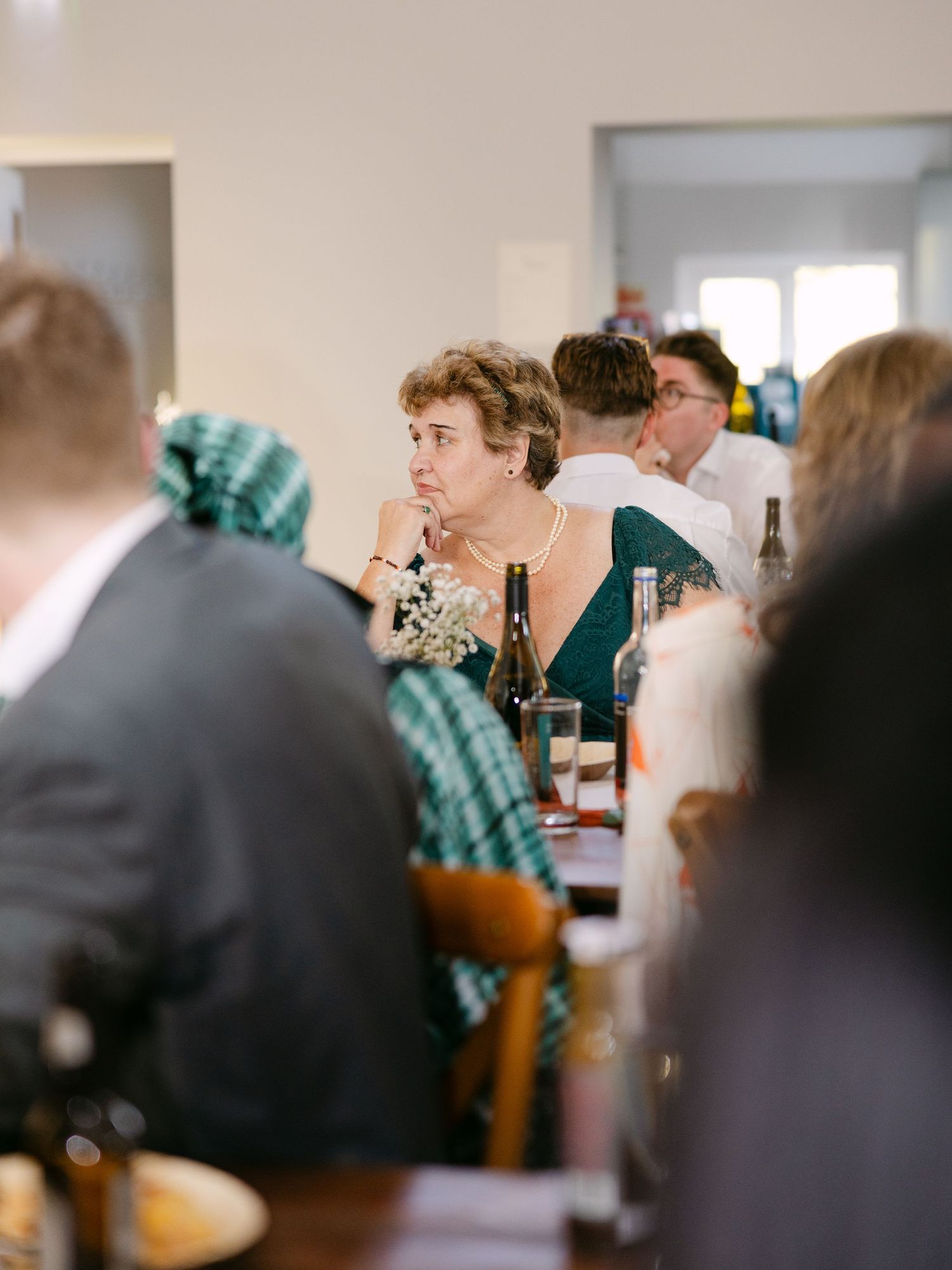 Wedding reception guests seated at tables in an indoor venue.
