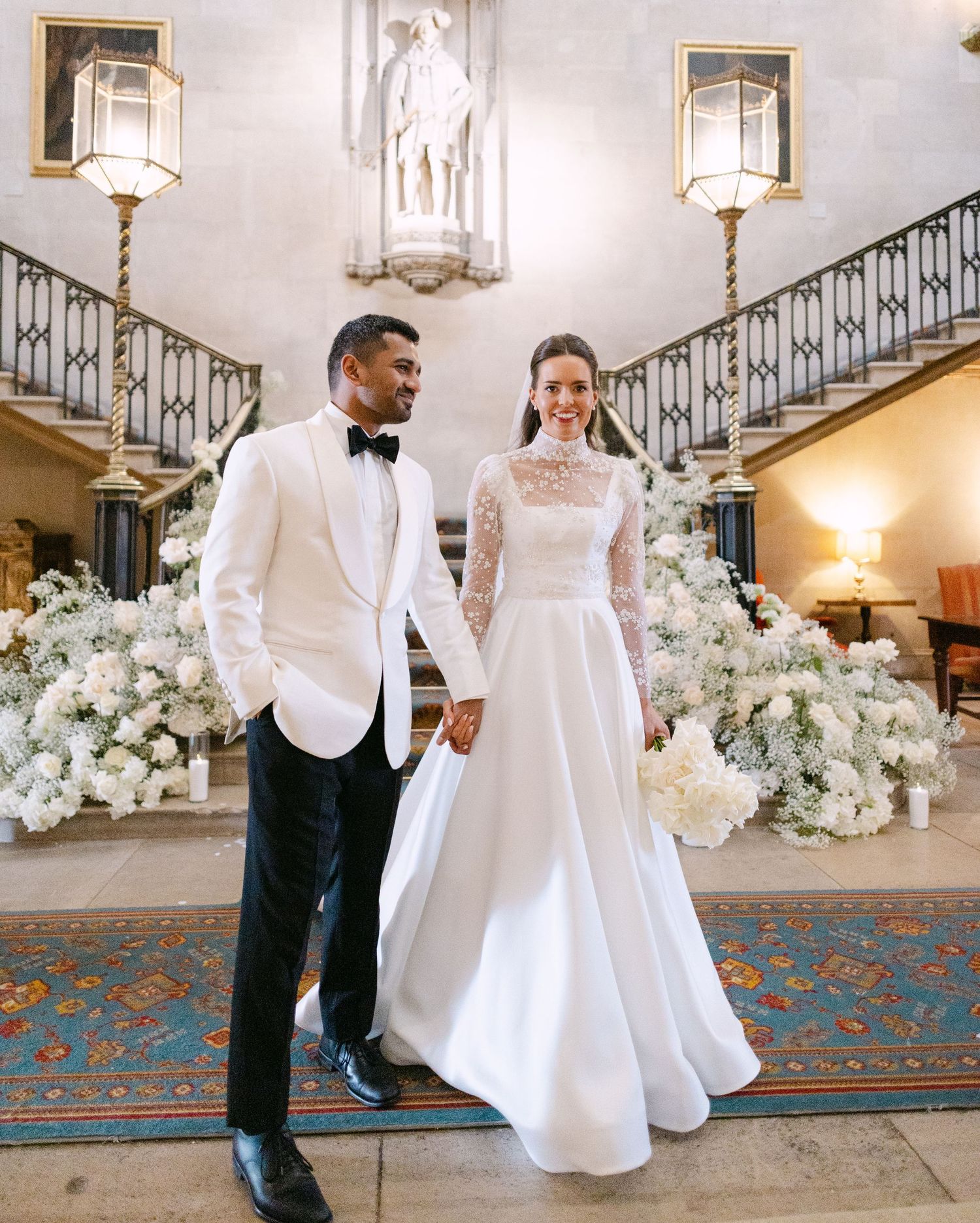 Newlyweds celebrate at the staircase in Ashridge House