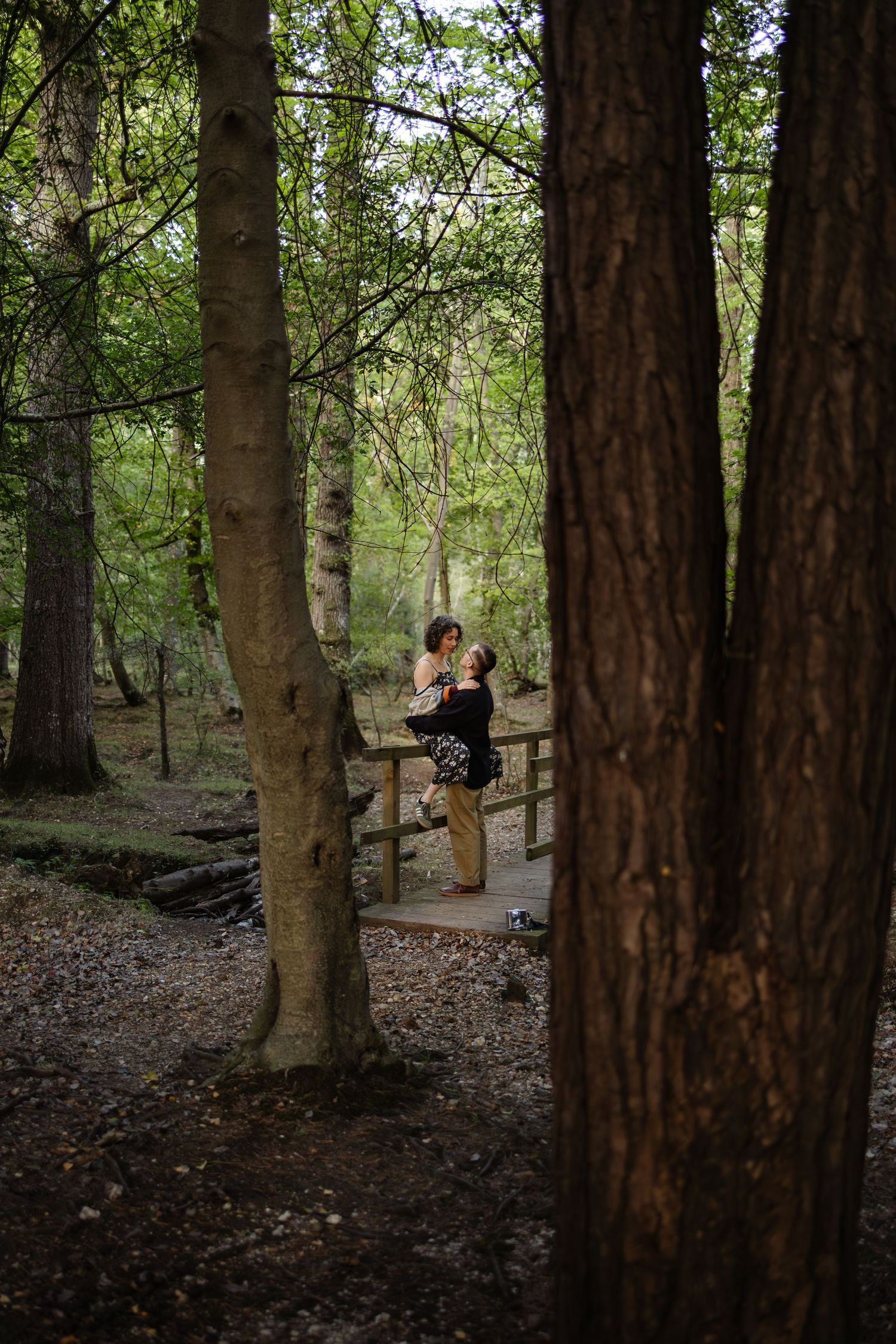 A distant view of a couple in a serene forest setting.