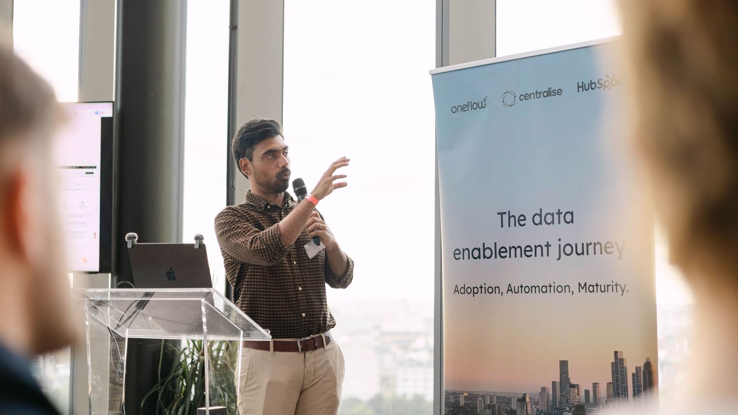 Speaker presenting at a data enablement journey conference on adoption, automation, and maturity topics.