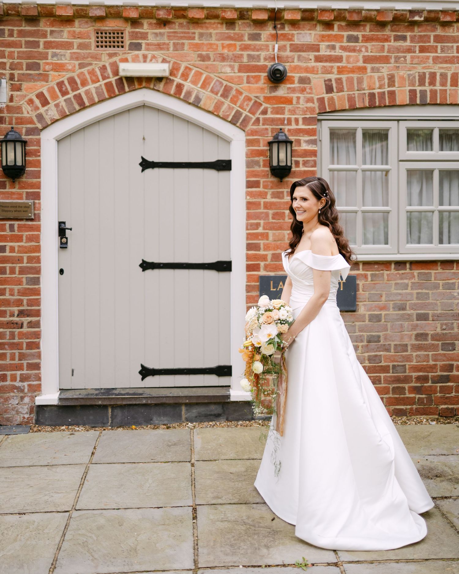 A series of shots showing a white wedding dress against a rustic brick wall with black door hinges.