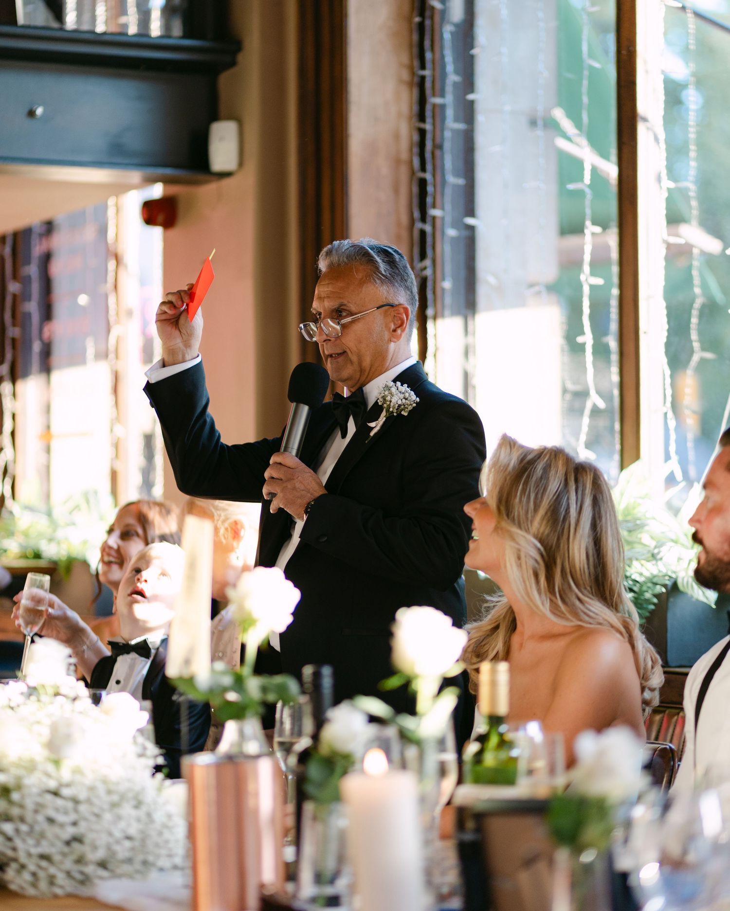 A speaker raises his glass during an emotional wedding toast at the reception.