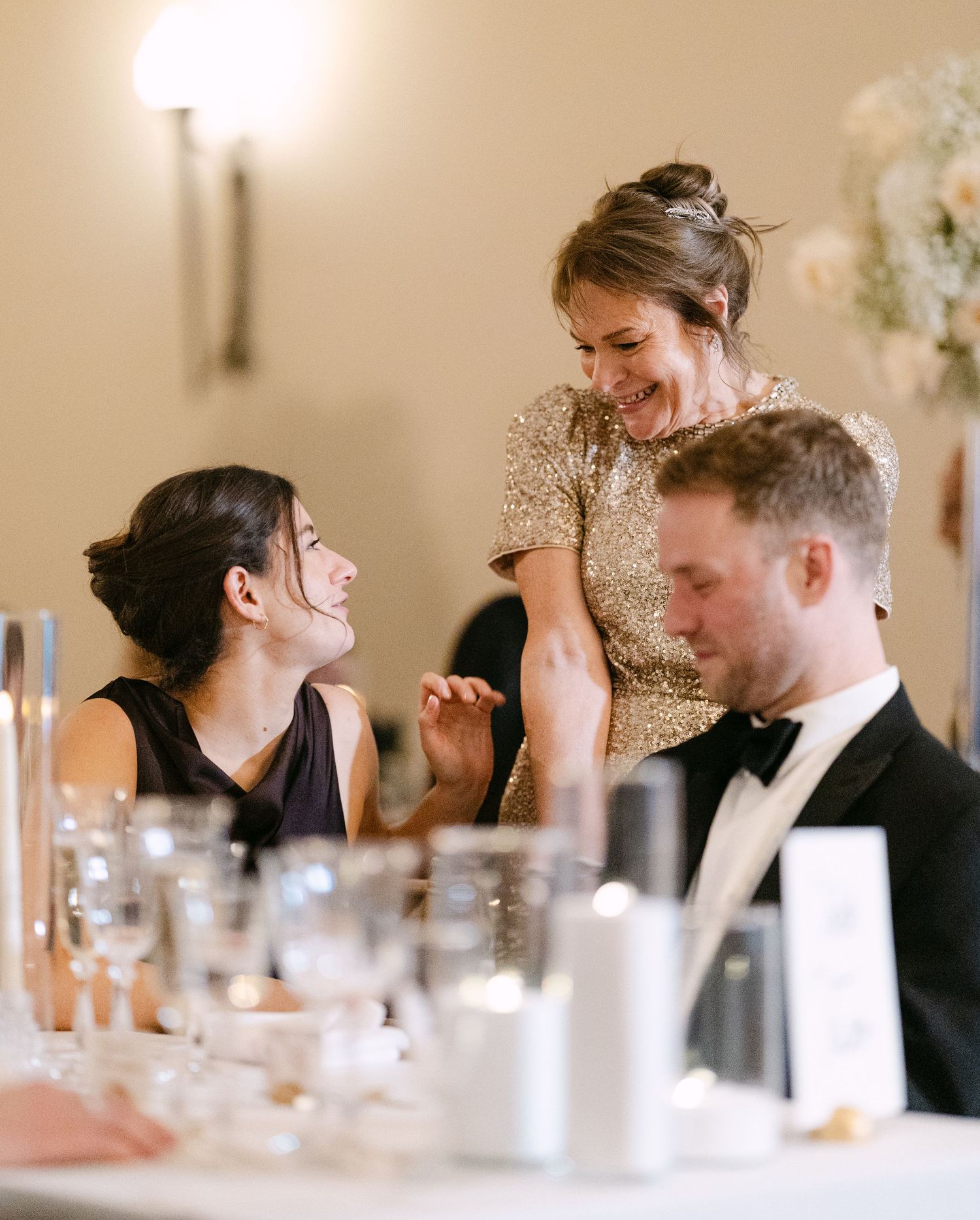 Mother of the bride wipes a tear away during speeches at Ashridge House, Hertfordshire