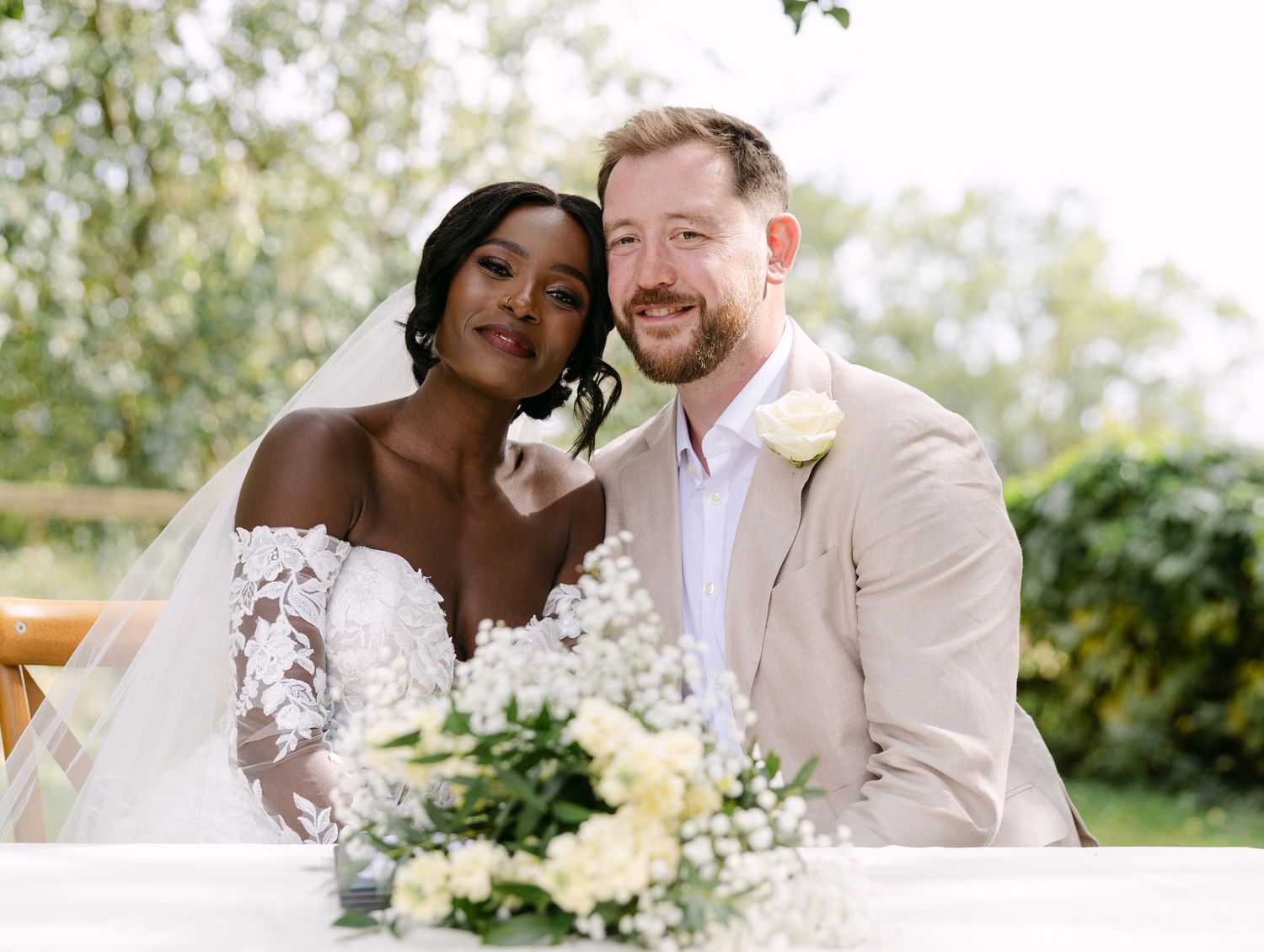 Romantic wedding portraits captured in a sunlit garden setting.
