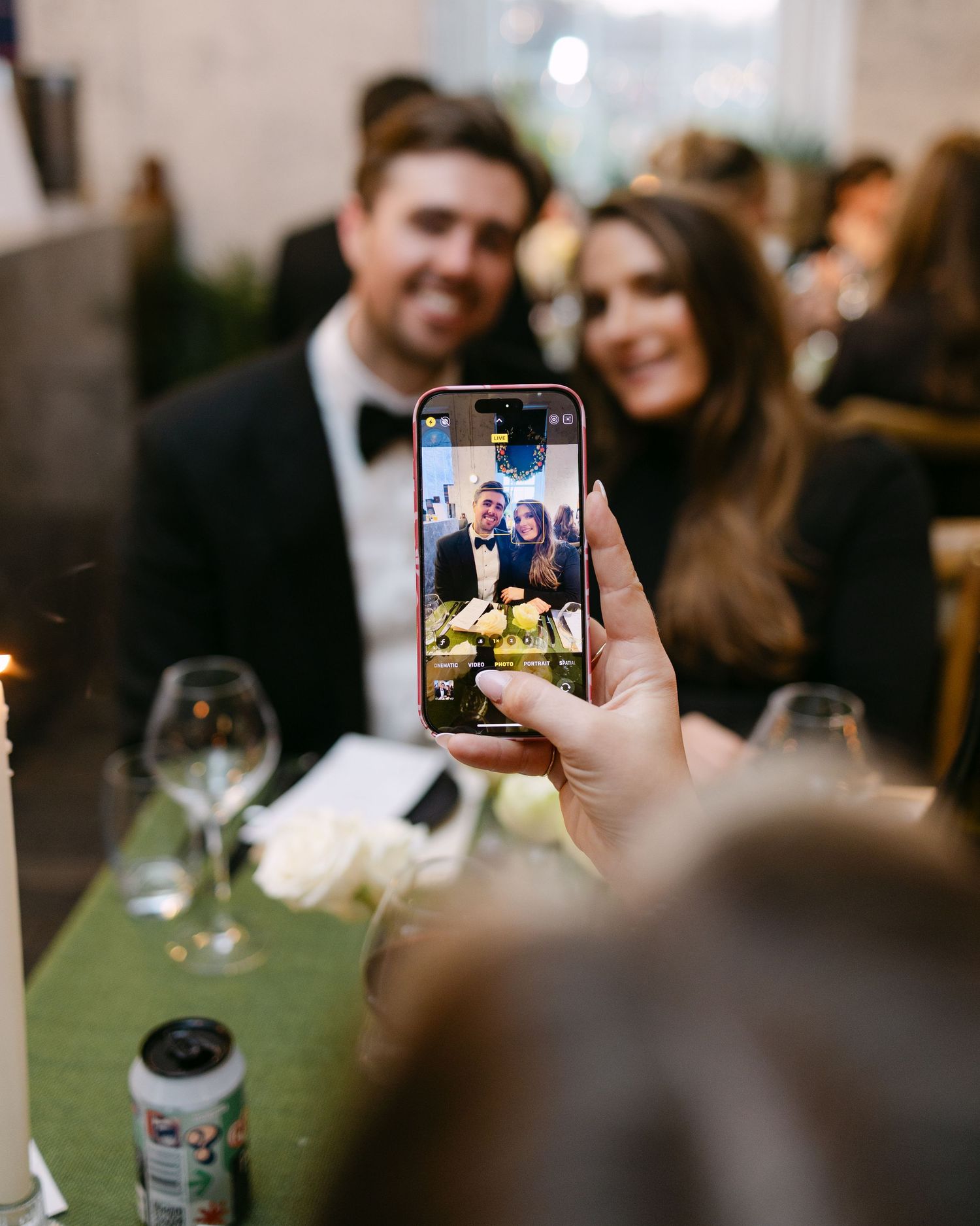 A guest takes a photo on their phone of other wedding guests in London