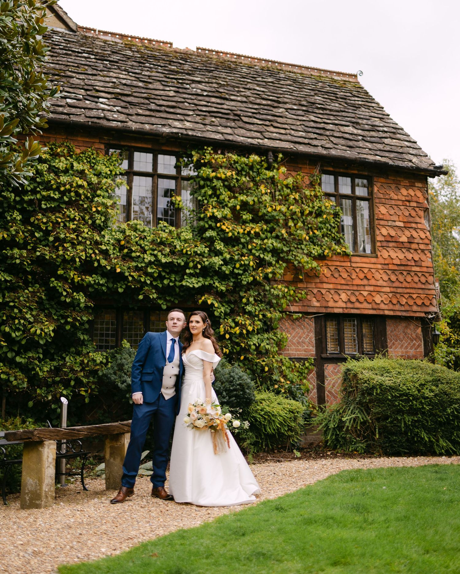 Wedding photos taken outside a charming brick cottage with ivy-covered walls.