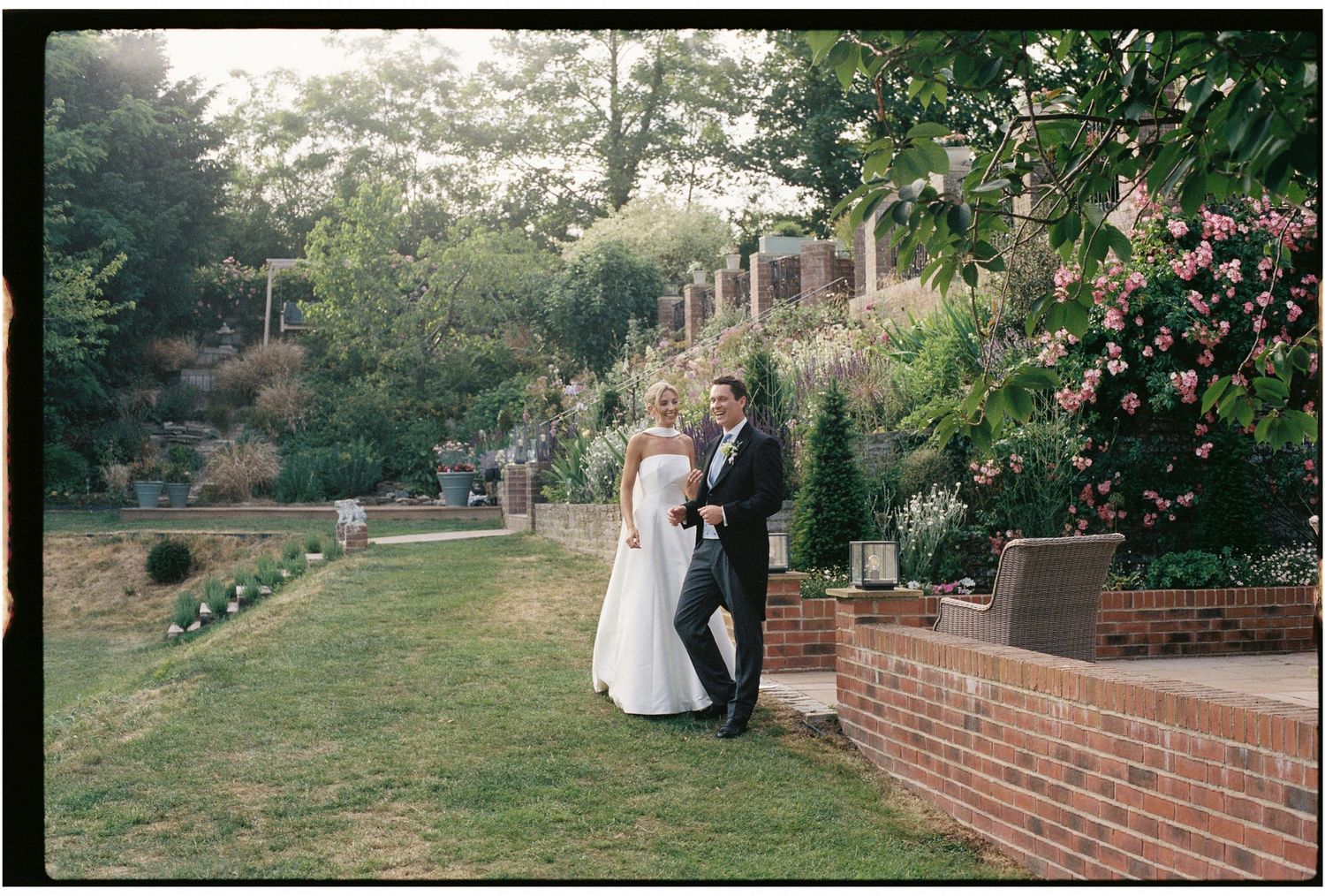 Bride and groom standing together in a lush garden setting on their wedding day.