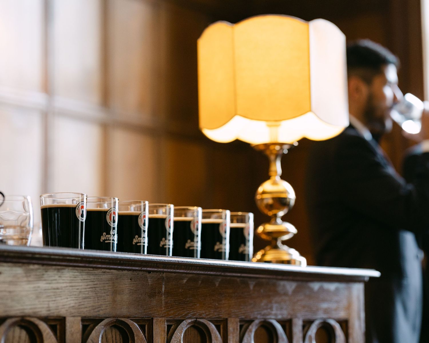 Warm-lit wedding reception venue with elegant table settings and chandeliers.