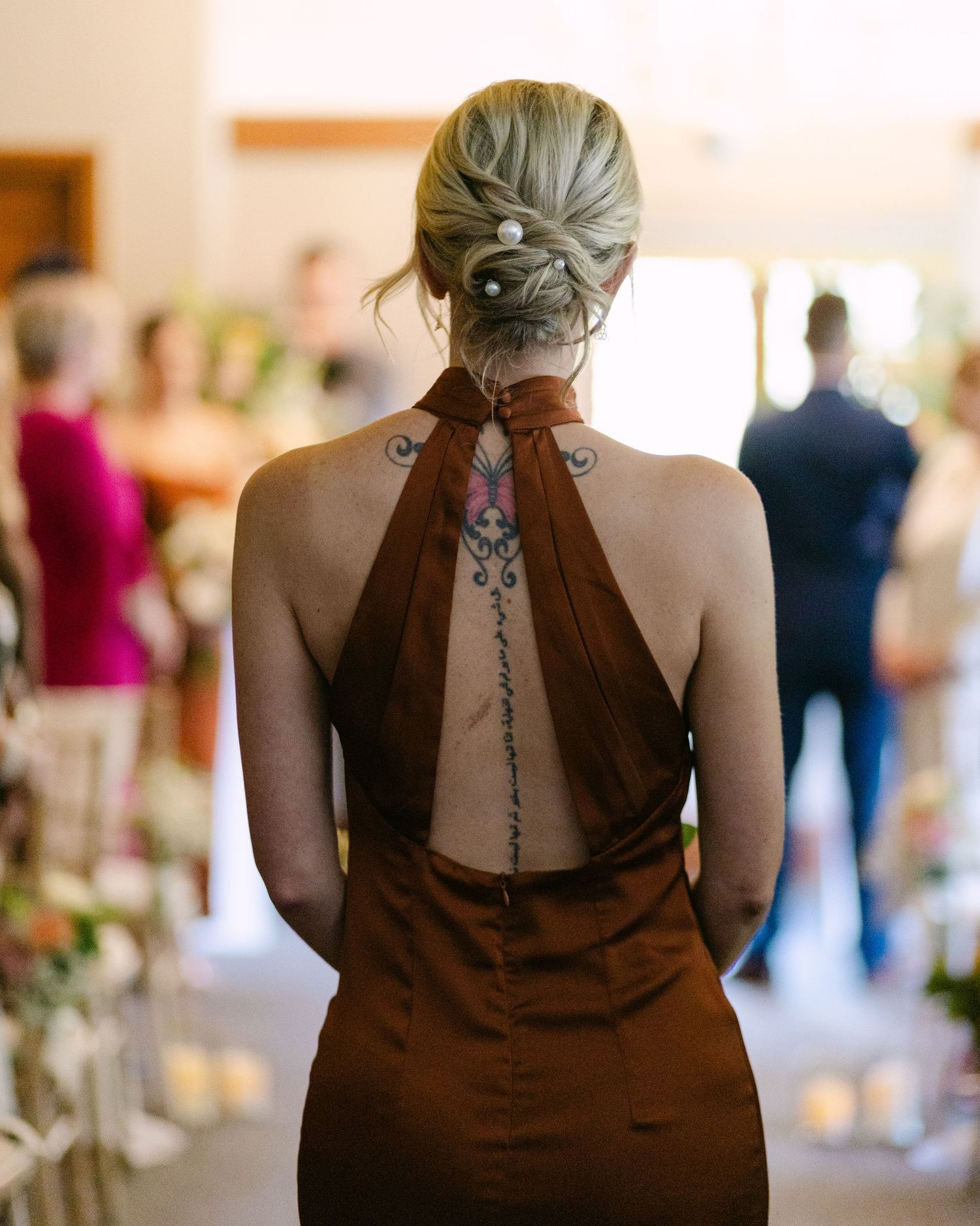 Back view of bridesmaids in brown dresses showing detailed halter necklines.