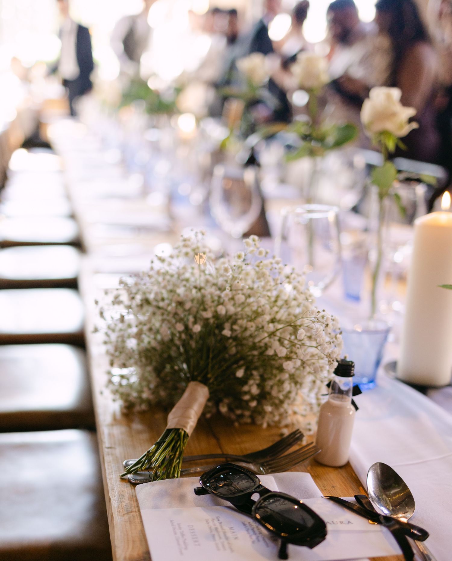 Wedding reception table settings decorated with delicate baby's breath flower centerpieces.