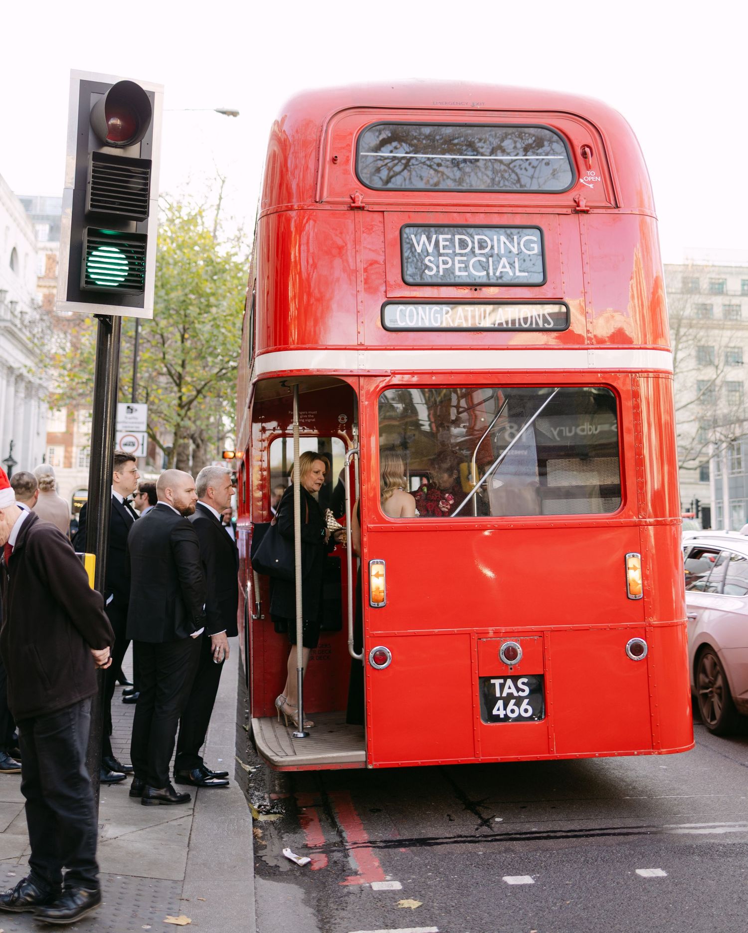Classic red London double-decker bus decorated for wedding transportation.