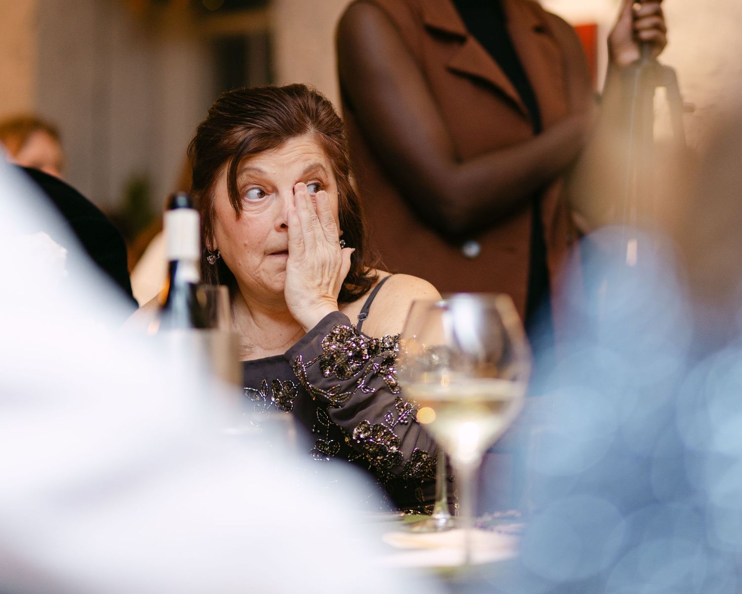 Candid moments of guests enjoying themselves during an evening wedding reception.