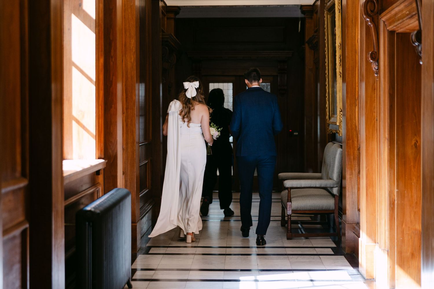 Sunlight streams through wooden hallways during an intimate wedding moment at Old Marylebone Town Hall.