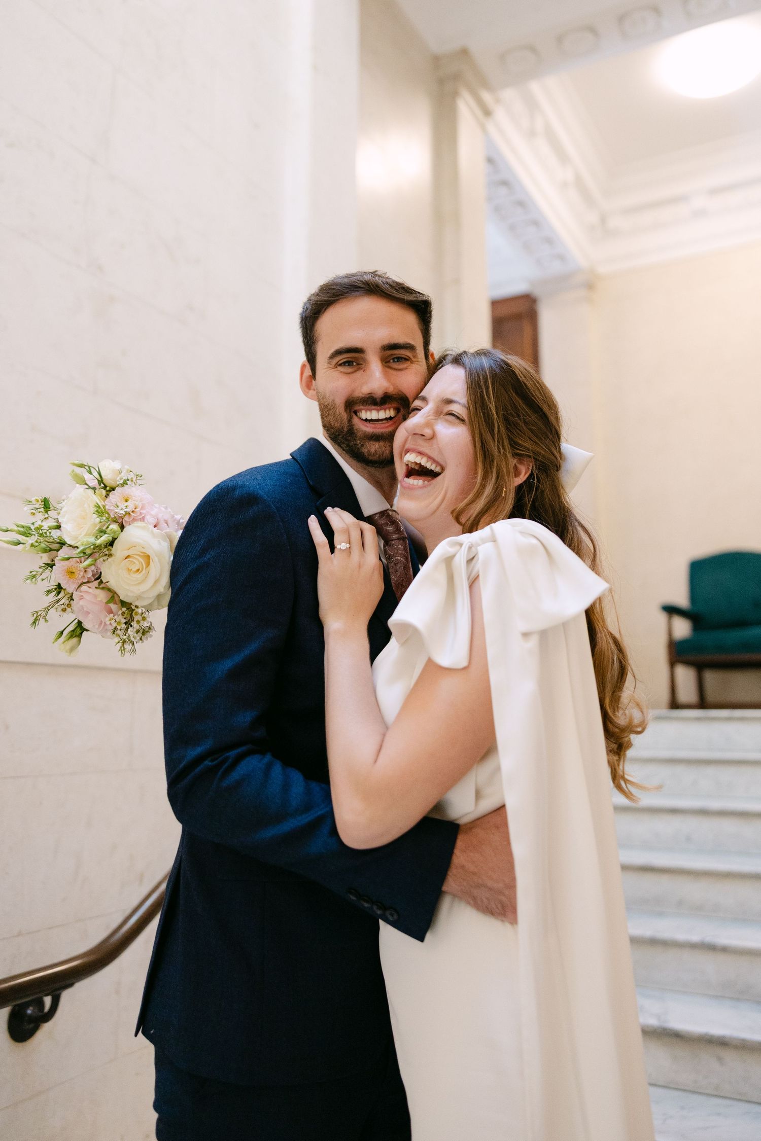 A couple embraces and laughs together on the steps at The Old Marylebone Town Hall.