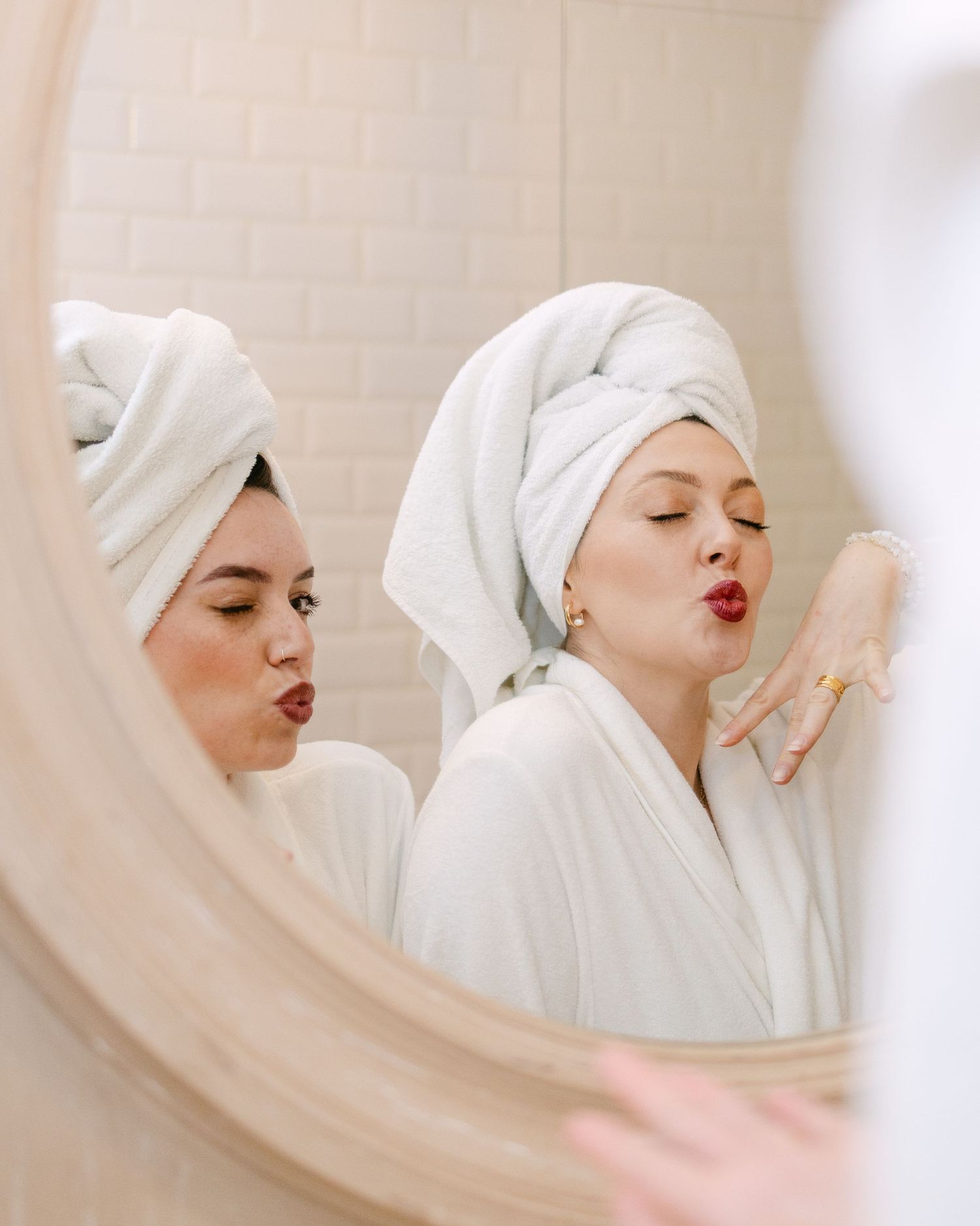 Multiple artistic portraits of someone wearing a white towel and red lipstick making playful expressions.