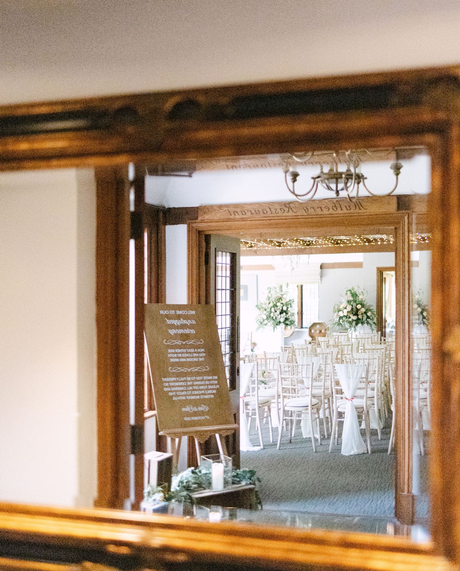 Rustic wooden beams framing a view of an elegant wedding reception venue setup at Langshott Manor.