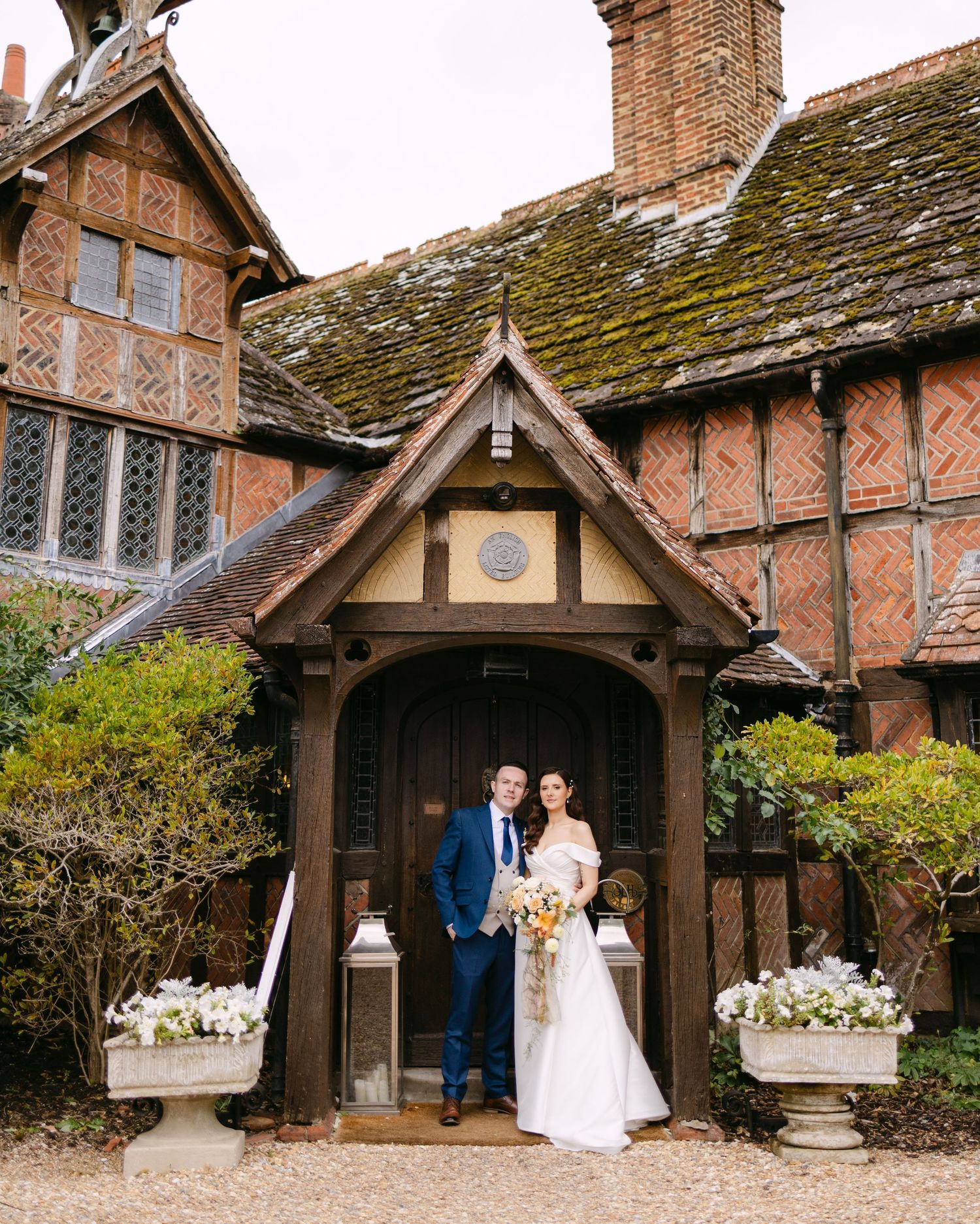 Tudor-style brick building serves as romantic wedding venue with moss-covered roof.