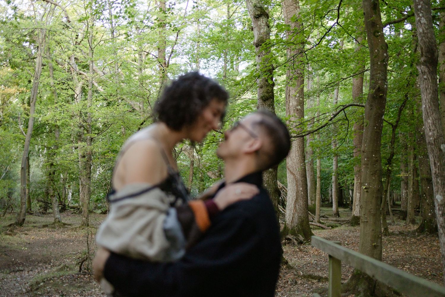A series of romantic moments captured between a couple in a wooded area.