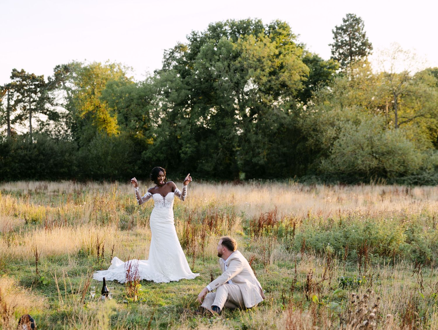 Wedding celebration in a rustic field with guests enjoying the outdoor setting.